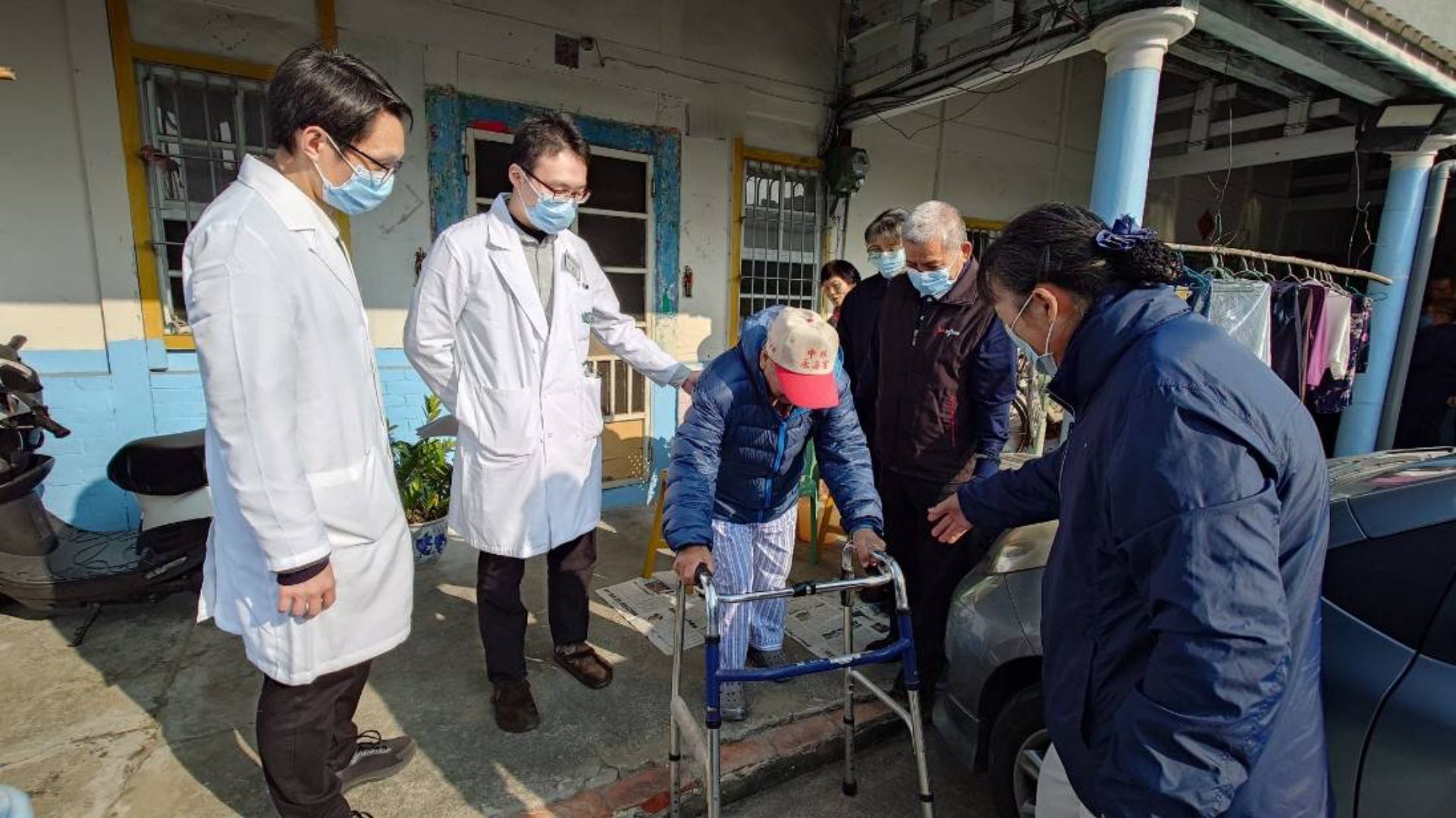 人醫會陪伴阿公活動筋骨,以助行器在庭院走路散步。