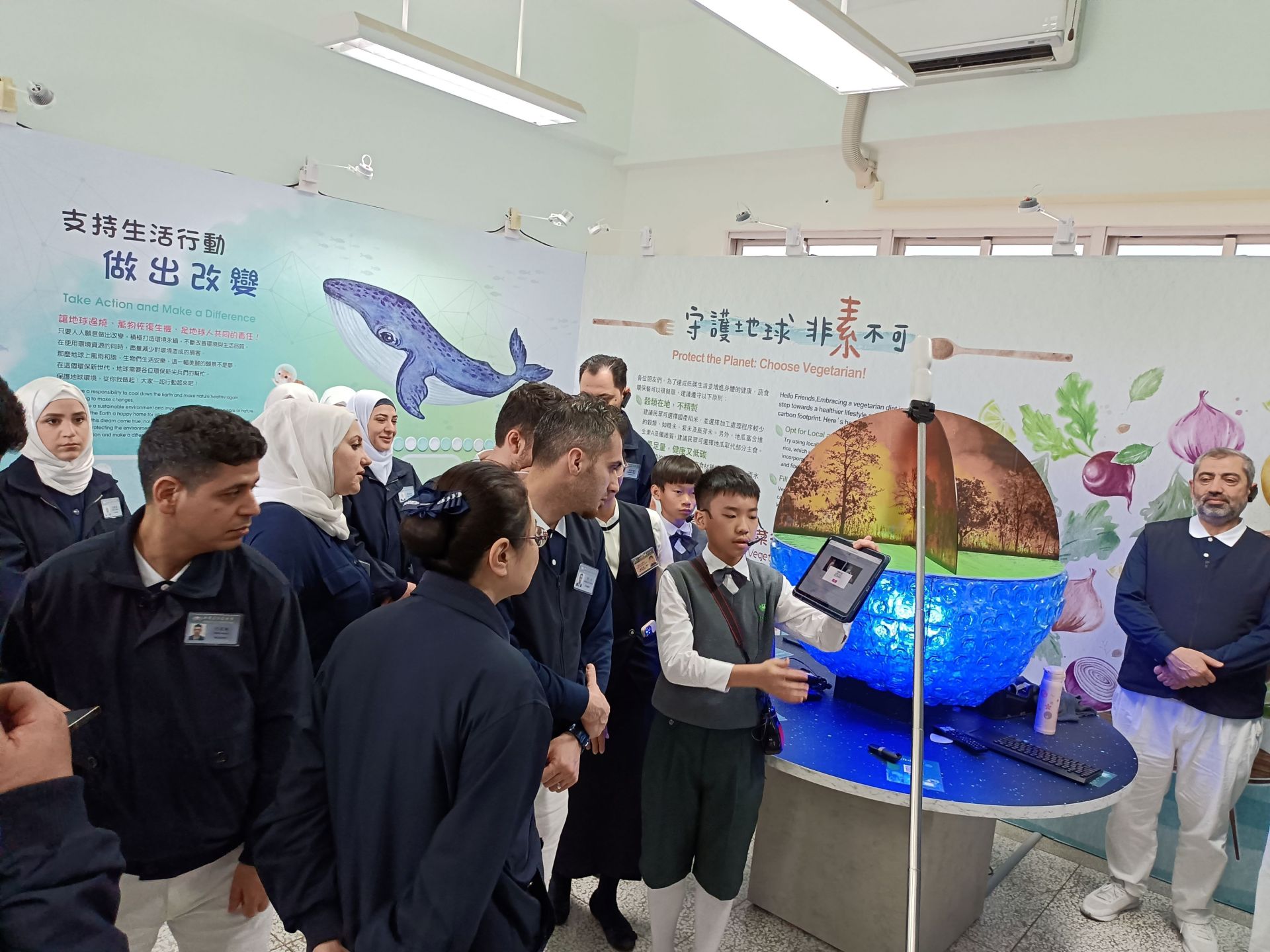 國小部小志工向滿納海學校老師介紹環保教室。