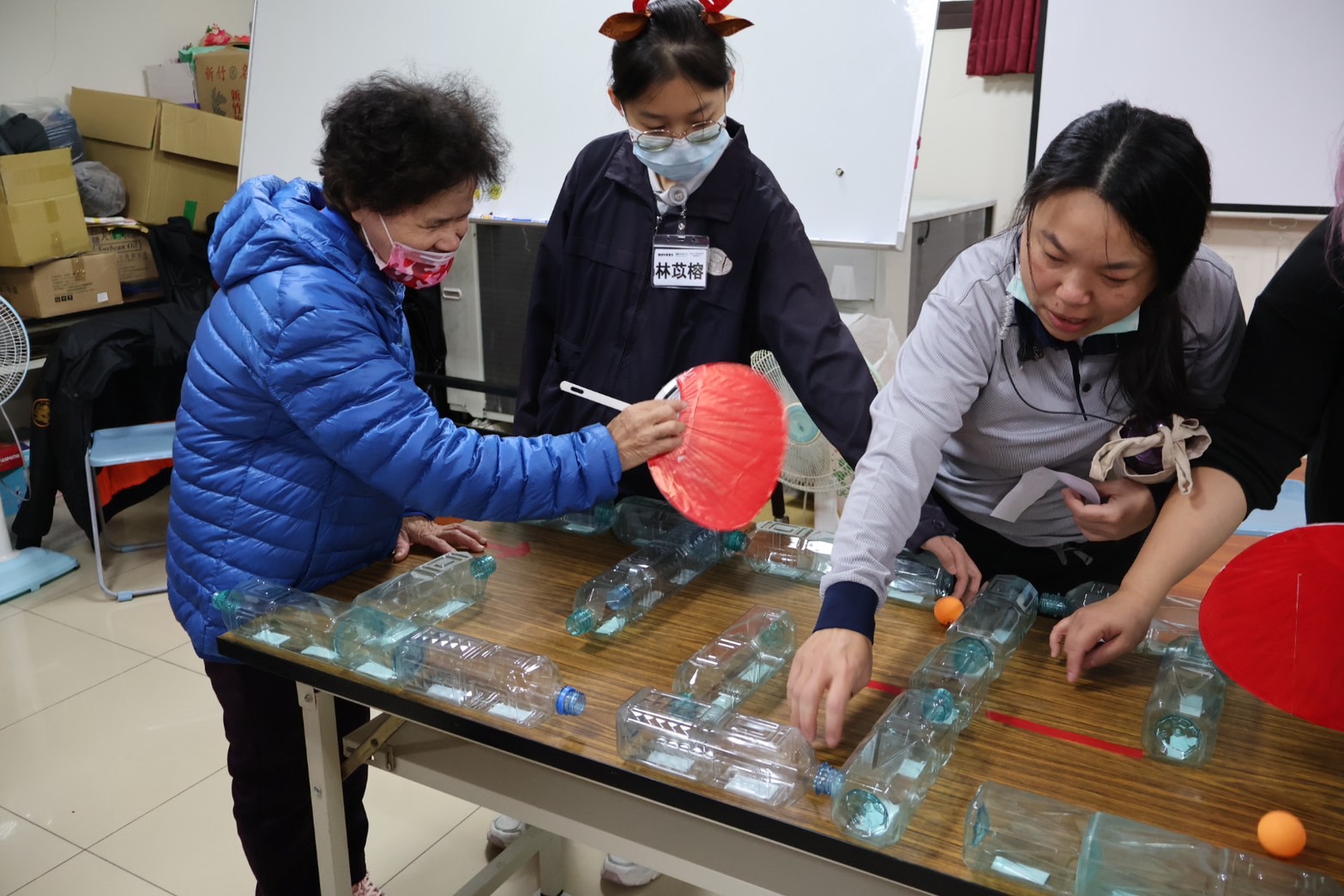 動動頭腦,手揮扇子讓兵乓球走過迷宮的智力訓練,活絡長輩們的腦力。