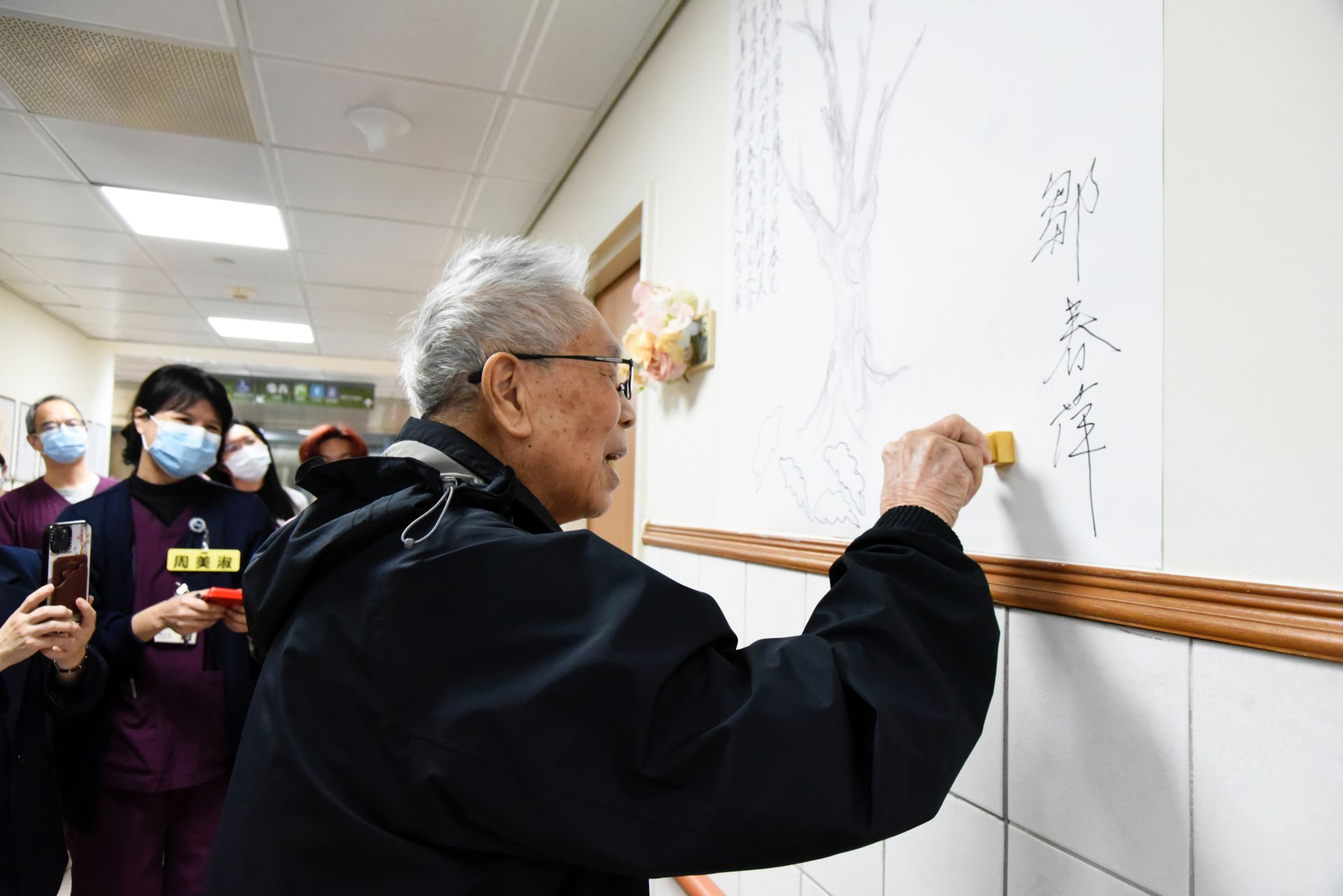 鄒爺爺在畫作上蓋章。