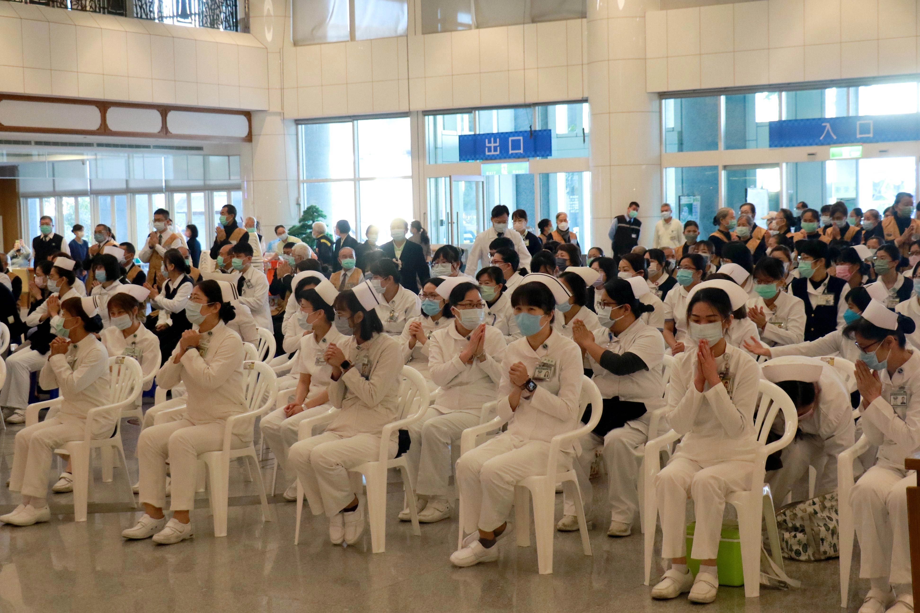 台中慈濟醫院恢復正常門診並舉辦新春團拜,醫護同仁與醫療志工雙手合十互相祝福。