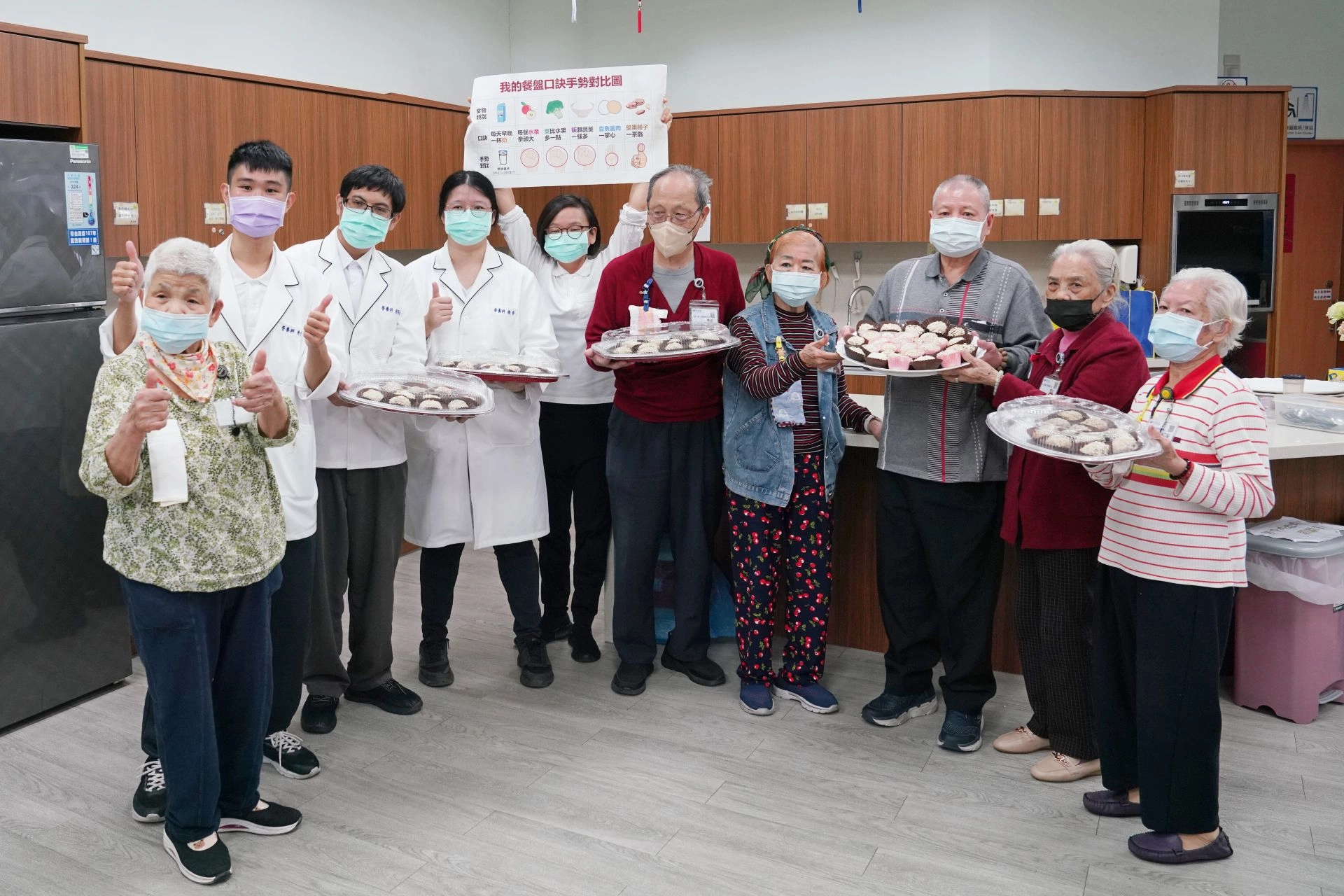 長輩們端著「燕麥棗泥元宵」成品,高興的與營養師一起慶祝營養師節快樂