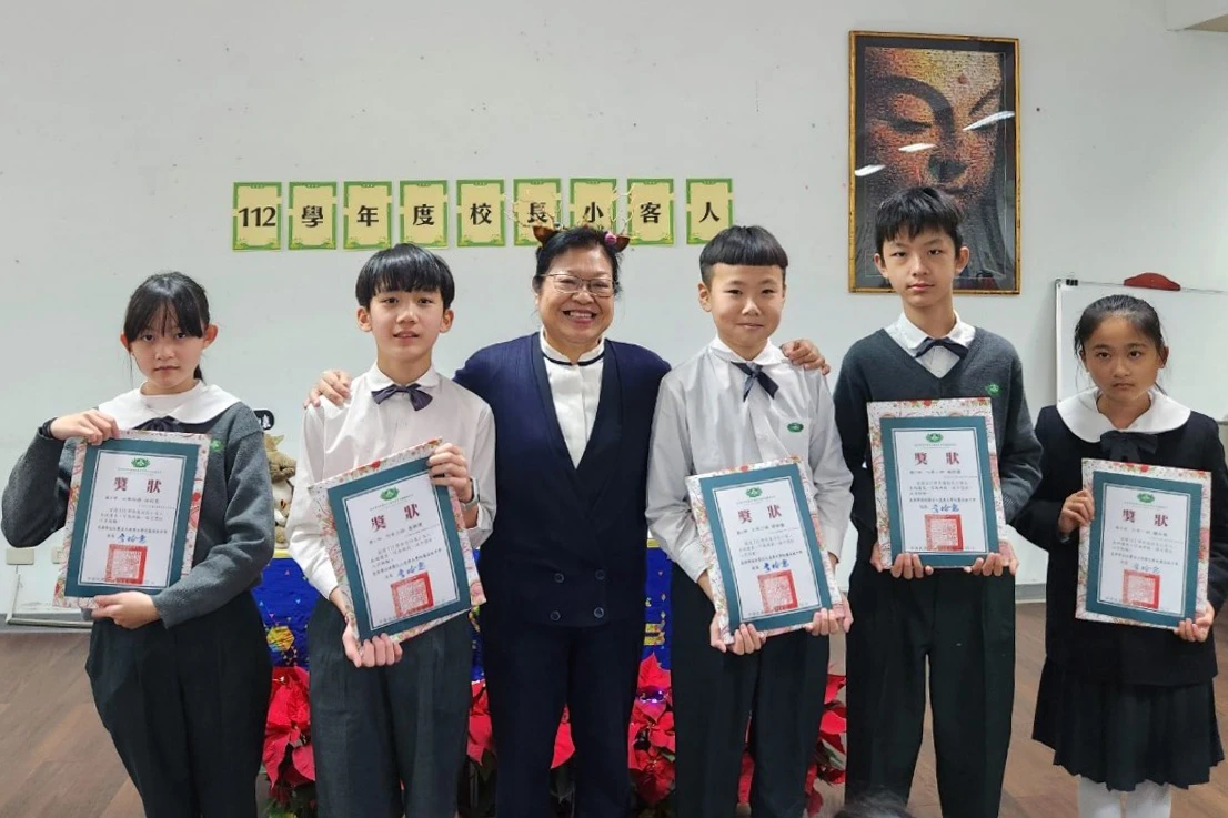環保小局長魯同學(左二)和副局長的施同學(右二)因為樂於付出的志工精神,同時獲得校長嘉獎