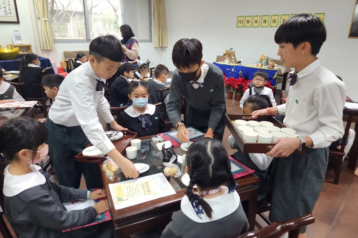 茶會結束前,六年級的大哥哥們,主動幫弟弟妹妹們收拾桌上的茶具與點心盤。