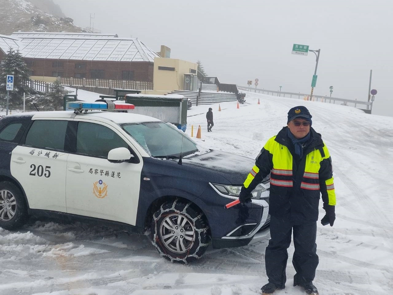 1月23日合歡山下雪,員警在寒風低溫中執勤、協助民眾。