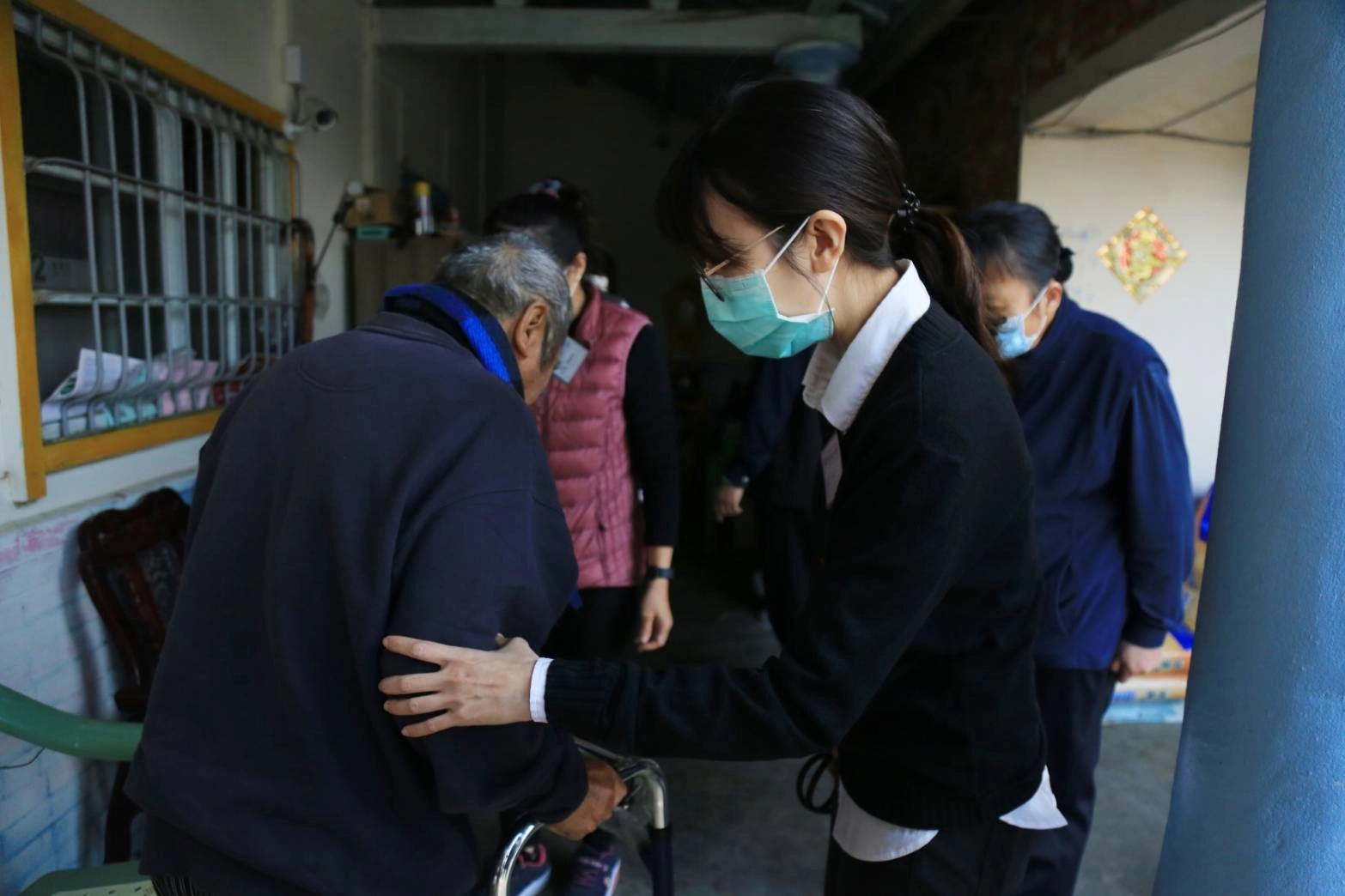 大林慈濟醫院黃欣寧醫師輕扶行動不便的長者,並幫其看診。