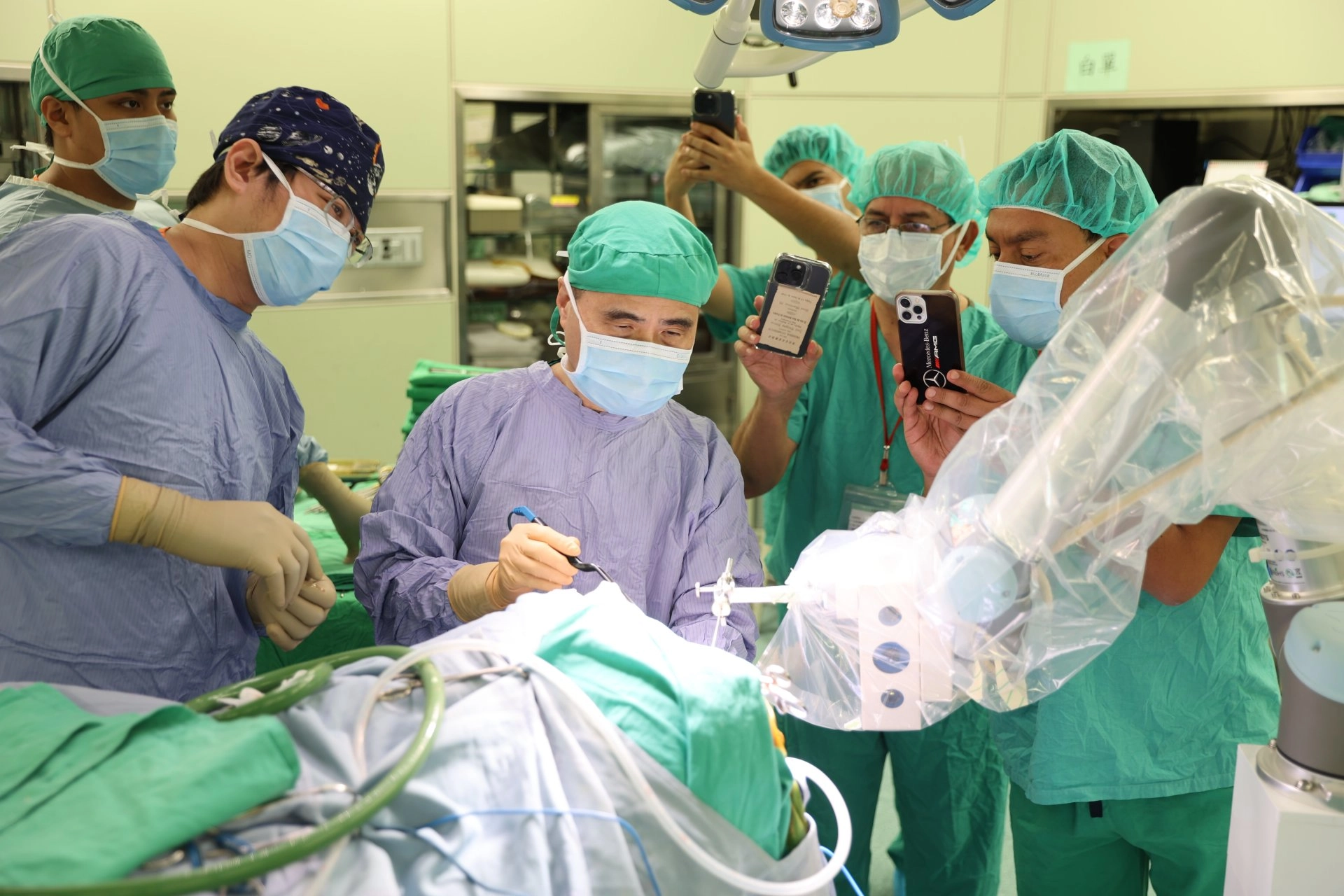 玻利維亞的Hospital Arco Iris代表團參訪花蓮慈院與鈦隼生物科技公司合作設置的「腦部手術機器人訓練中心」,觀摩邱琮朗教授(左三)等神經外科團隊執行手術。