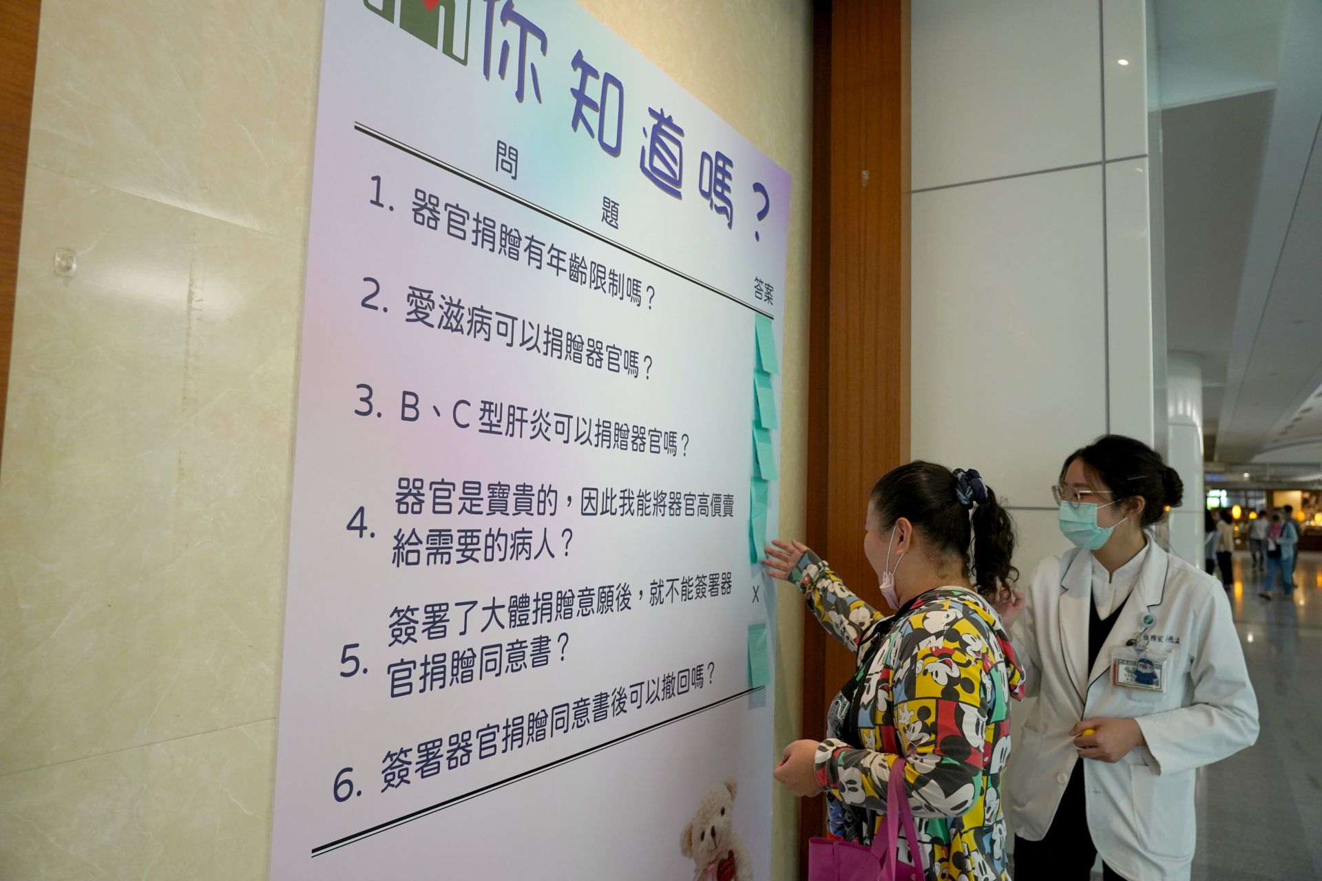 活動現場設有看板列出常見的器官捐贈迷思,邱小姐(左)經社工師解說才明白簽署大體捐贈與器官捐贈兩者並不衝突。