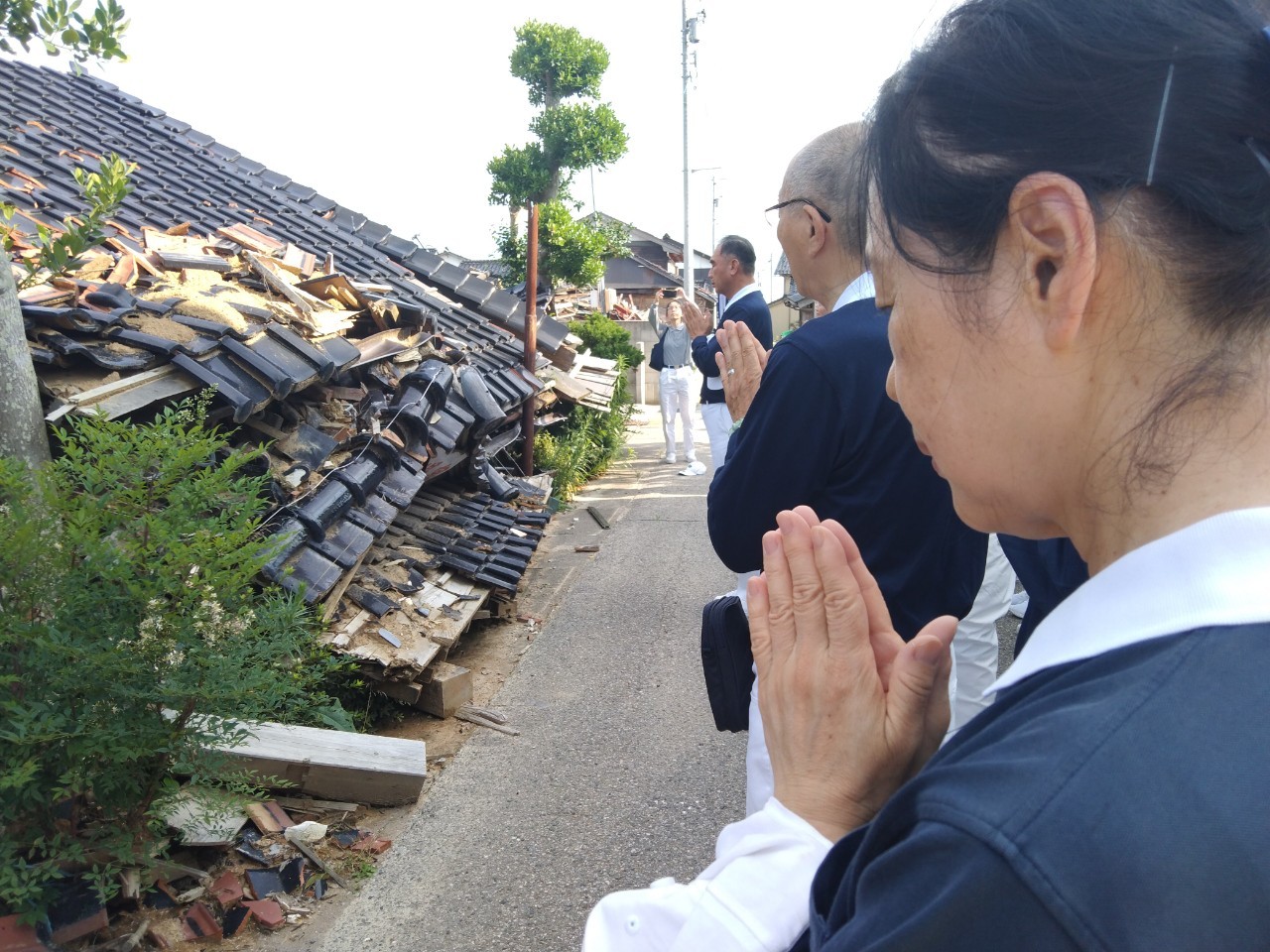 慈濟團隊巡訪途經有往生者的房屋，駐足停留虔誠祝禱祈求「往者靈安、生者心安」。