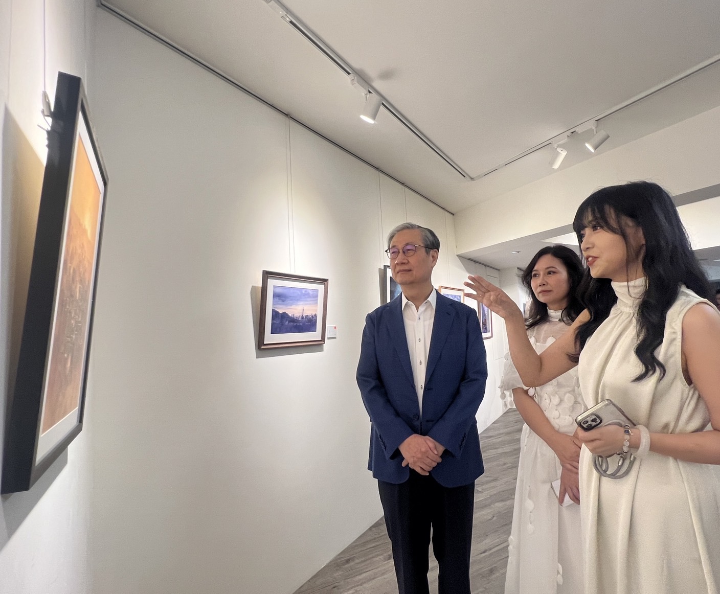 蘭嵐(右)、彭嵐(中)為移民署署長鐘景琨(左)導覽並介紹畫作及創作理念