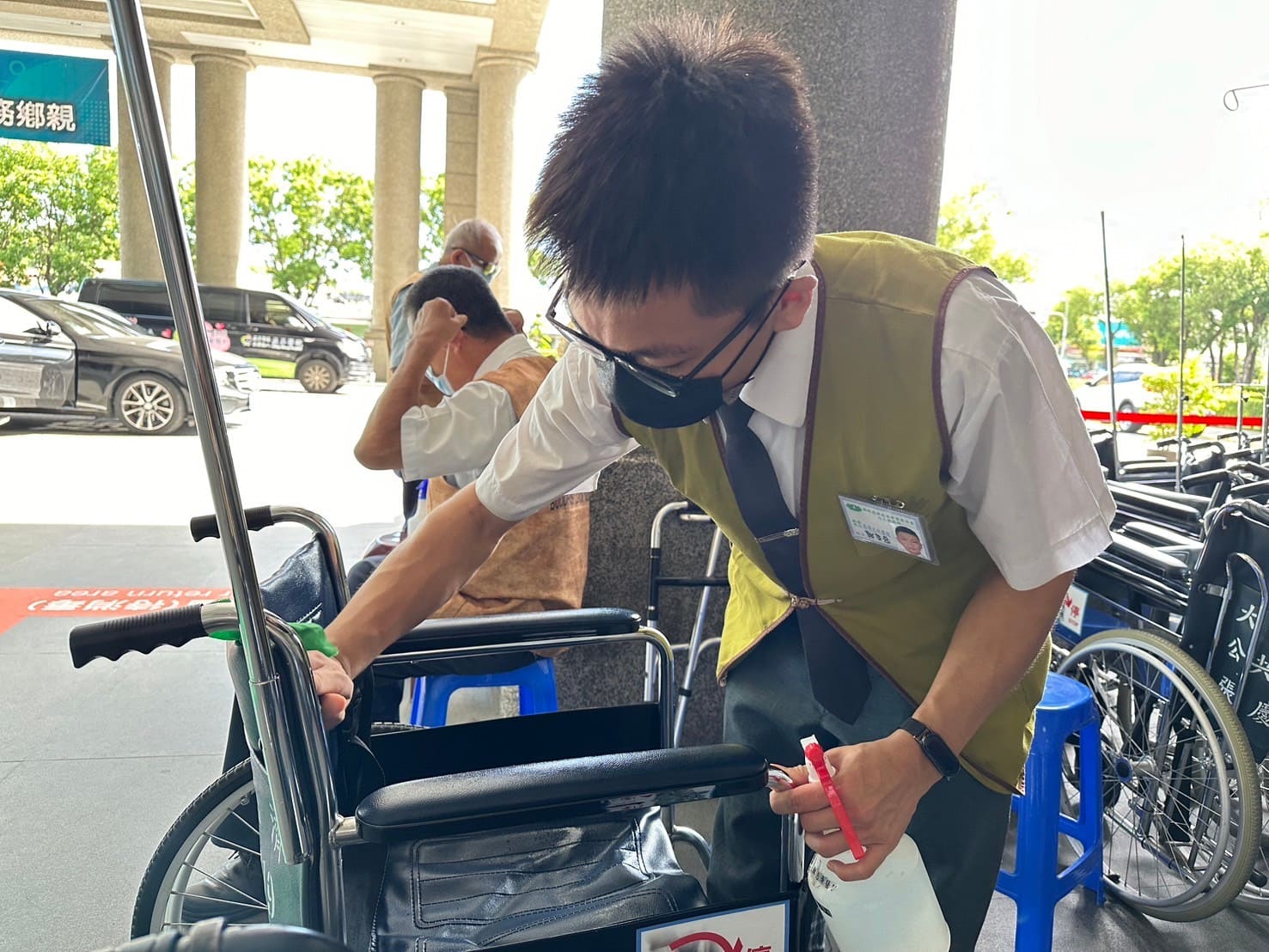 頂著大門外高溫,同學依舊細心消毒輪椅。