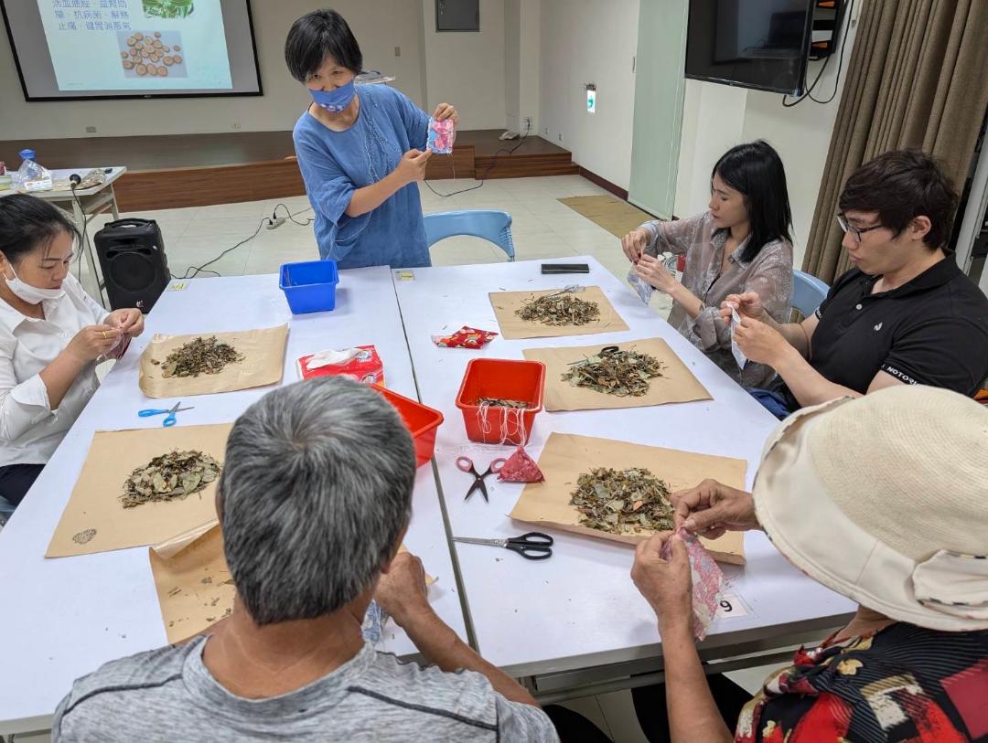 園藝治療師陳妙曼老師向新住民夫妻示範如何製作艾草馨香包