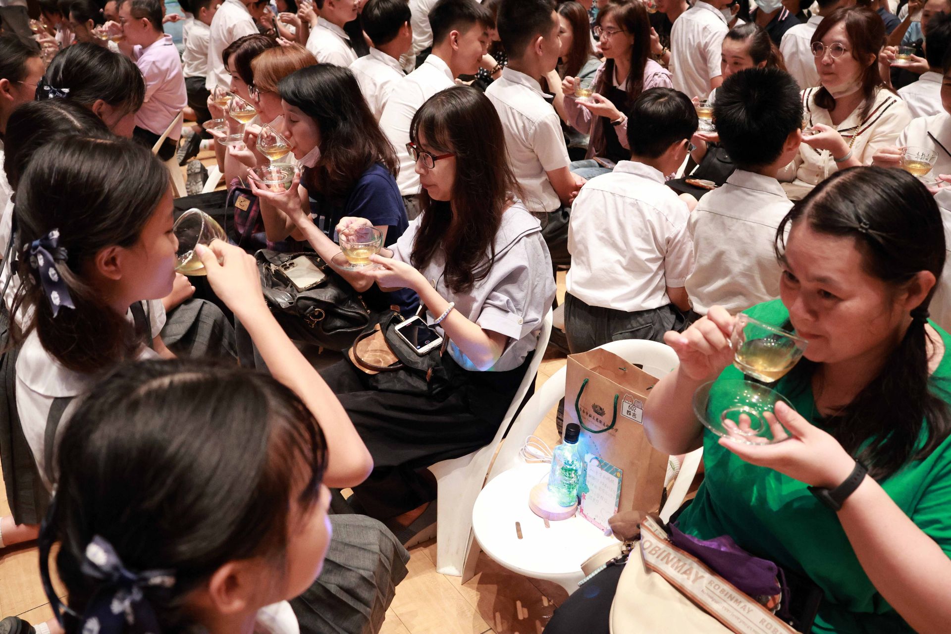 畢業生恭敬的以一杯茶水與手製浮游花影燈禮敬父母,感恩父母的養育之恩與無私付出。
