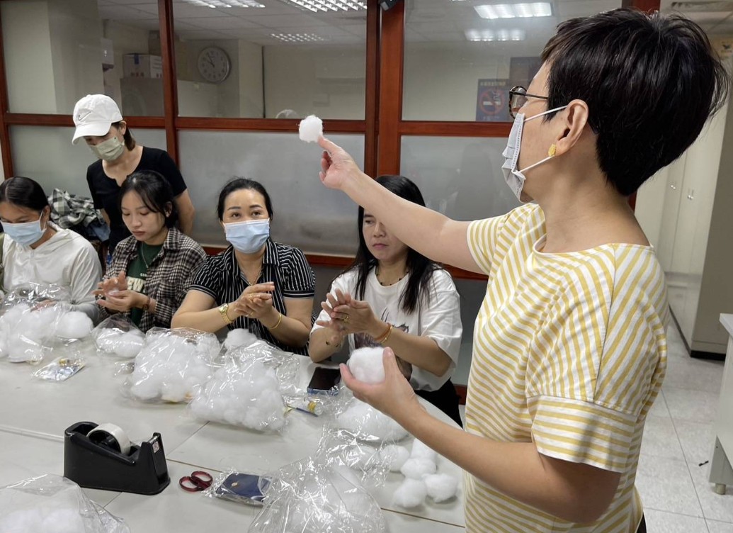 雲朵燈課程講師施慧凌(右一)為新住民學員講解如何運用棉花塑形雲朵模樣。