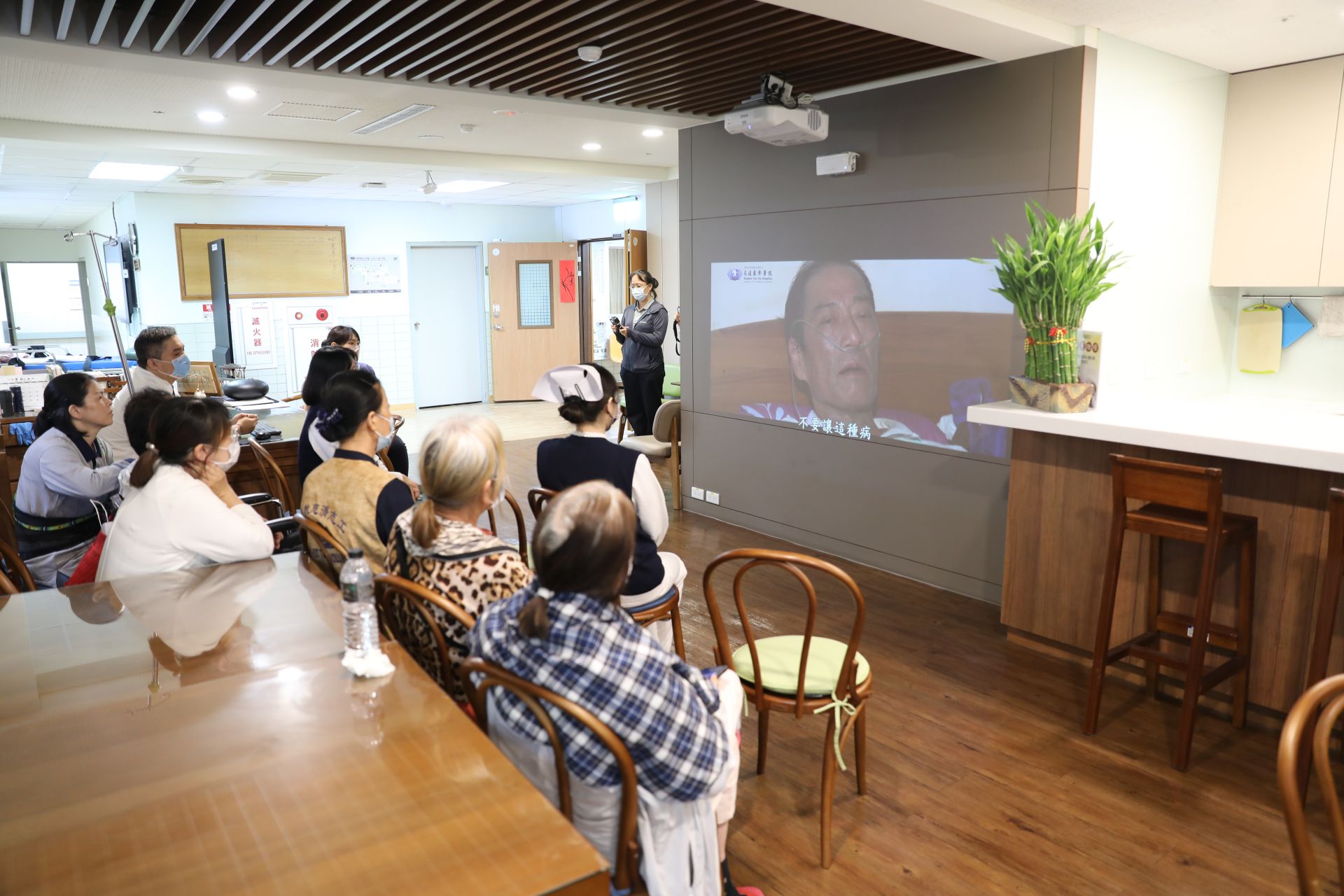06/26下午,花蓮慈院團隊在心蓮病房交誼廳舉辦首映會,邀請團隊與志工一同見證,心蓮病房護理師鄧淯勻現場為林永金送上祝福的花束。