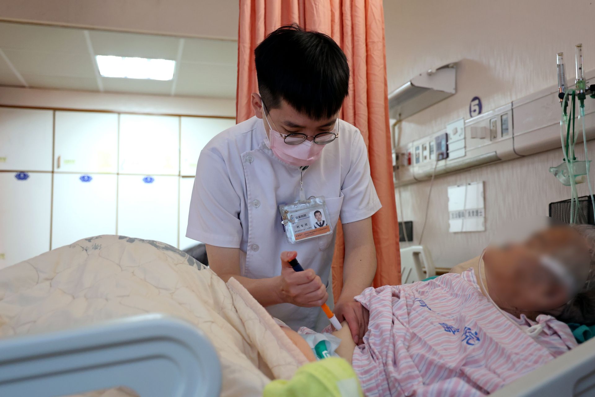 26歲的心蓮病房護理師柯智閔表示,因年紀相仿,他能更加同理現在年輕人的想法,因此會主動協助新進同仁適應職場環境。圖中為柯智閔為住院患者施打胰島素。