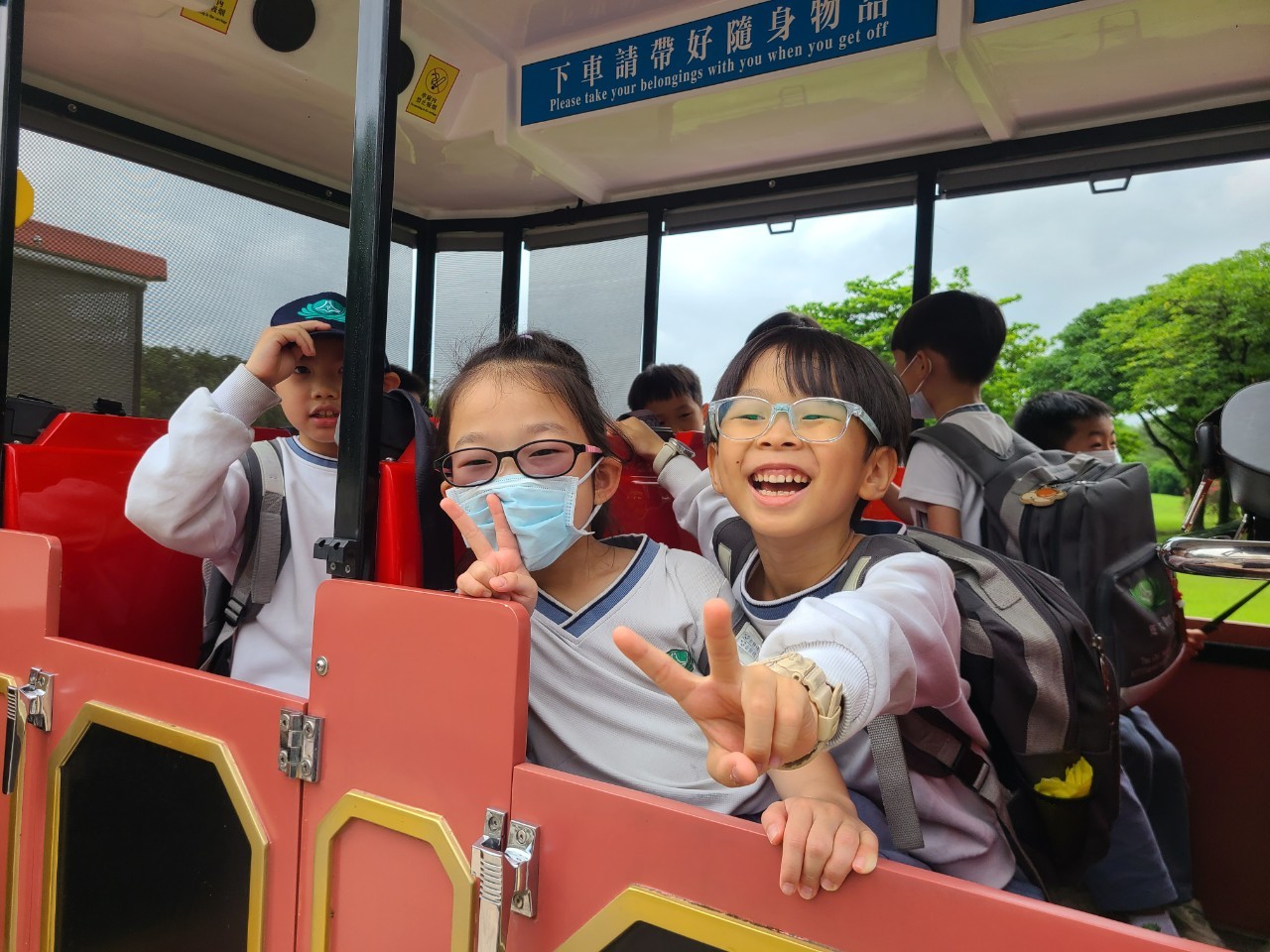 孩子和同學搭乘遊園車一起觀察動物,真是太棒了!