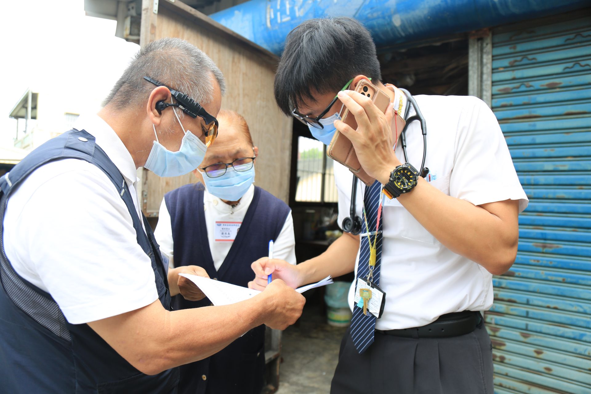 (上)張愷杰醫師(右)與藥師籃文檳,以電話聯繫社區藥局,並記下個案用藥情況,給予患者醫療的協助。