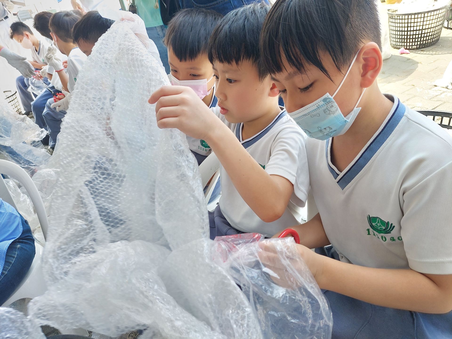 小朋友仔細的把塑膠袋整理好,把不能回收的部分剪下。