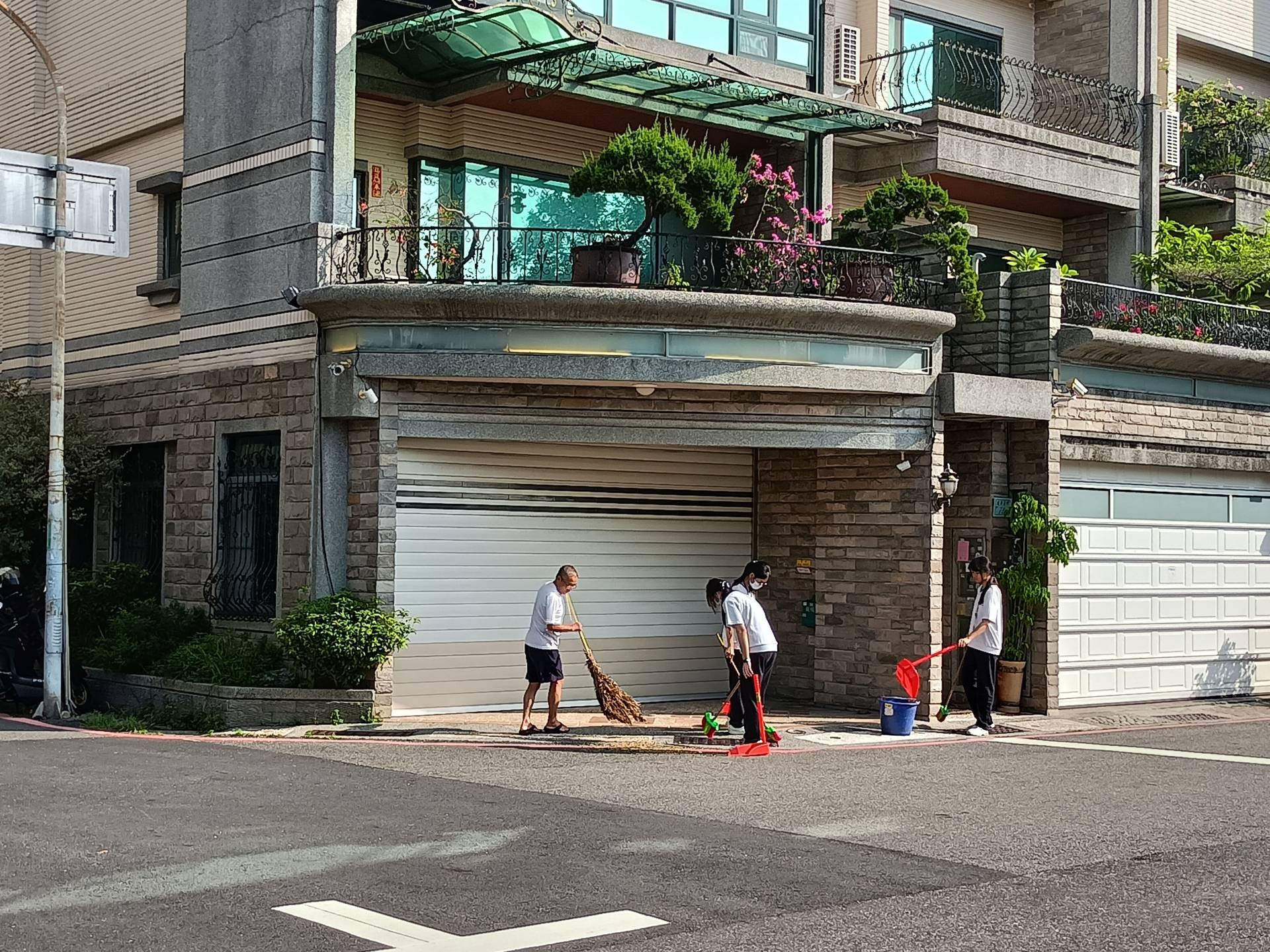 鄰近居民見臺南慈中的學生掃街,便從家裡拿出竹掃把一起參與。