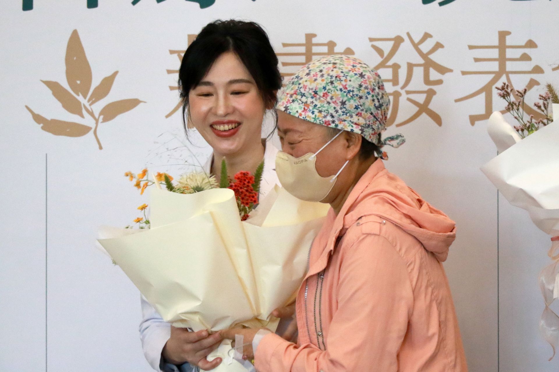 第四期淋巴癌病友鄭女士(右)在新書發表會上獻花給中醫腫瘤科主任莊佳穎醫師(左),感恩暖心治療與鼓勵,陪伴他走過抗癌之路。