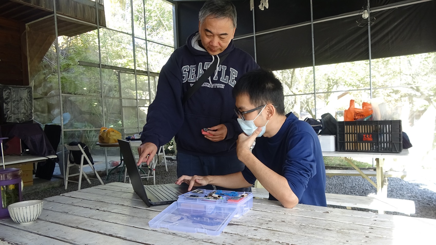 林宗宏教授與學生架設電腦及網路,再由大學生教導小朋友使用學習。