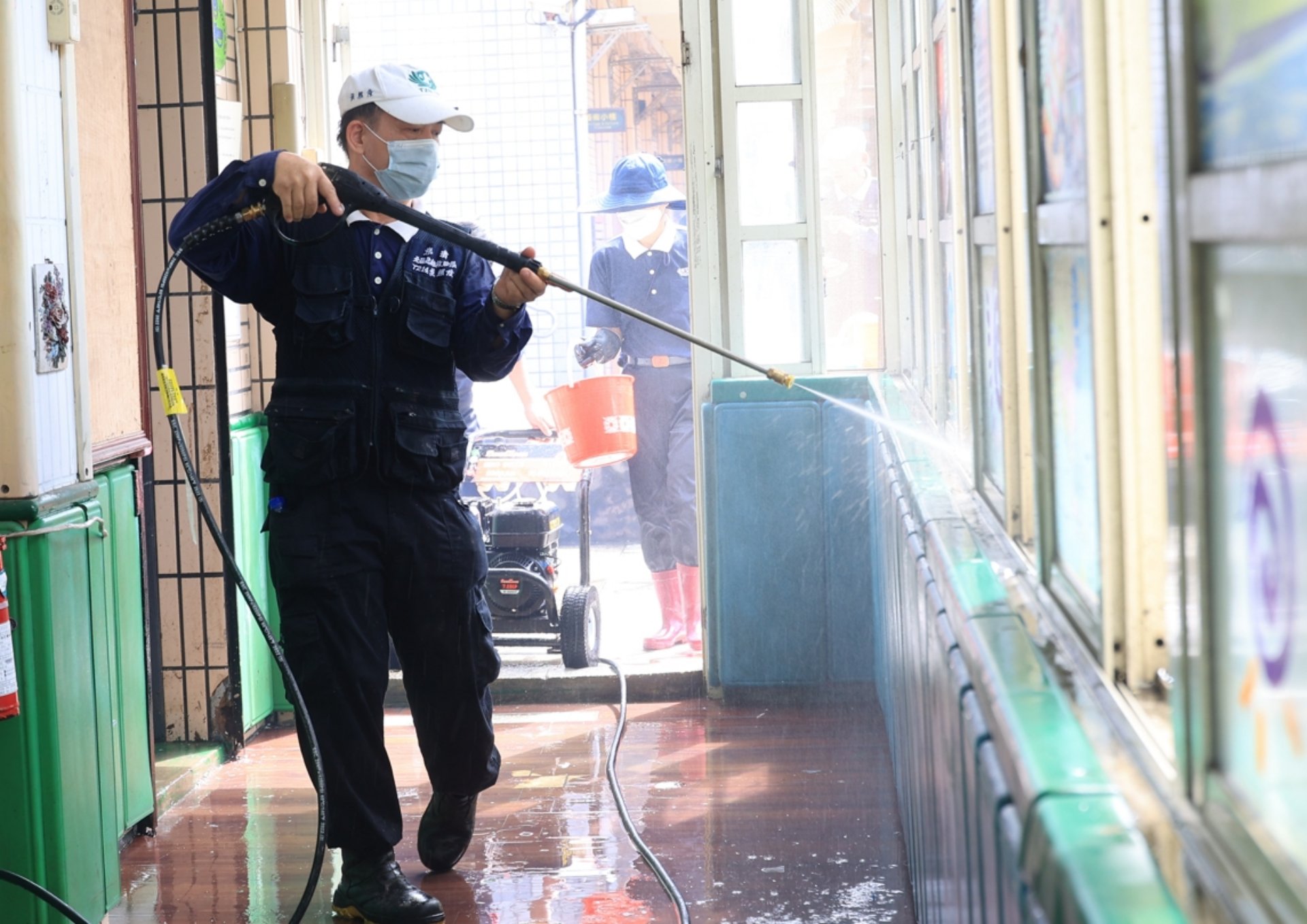 走道上、花臺邊,有些淤泥被太陽照得乾涸了,男眾志工就立即搬來高壓沖水機,以強力水柱沖洗。