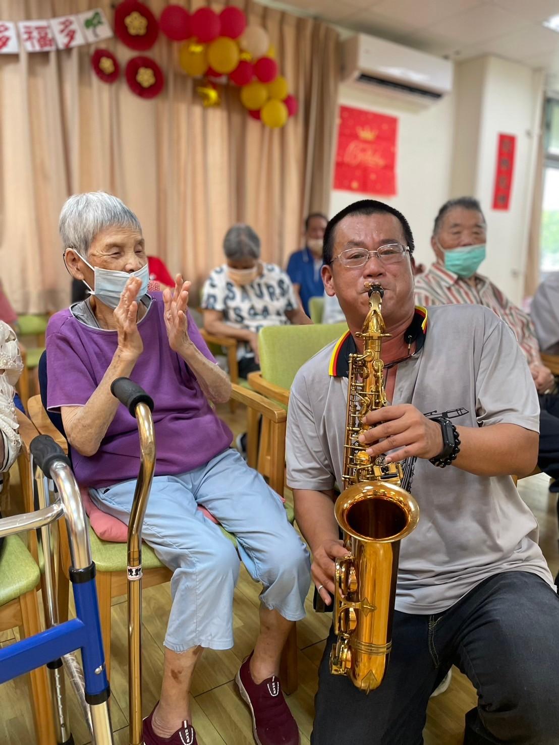 薩克斯風吹著阿嬤喜歡的曲子讓她笑開懷。