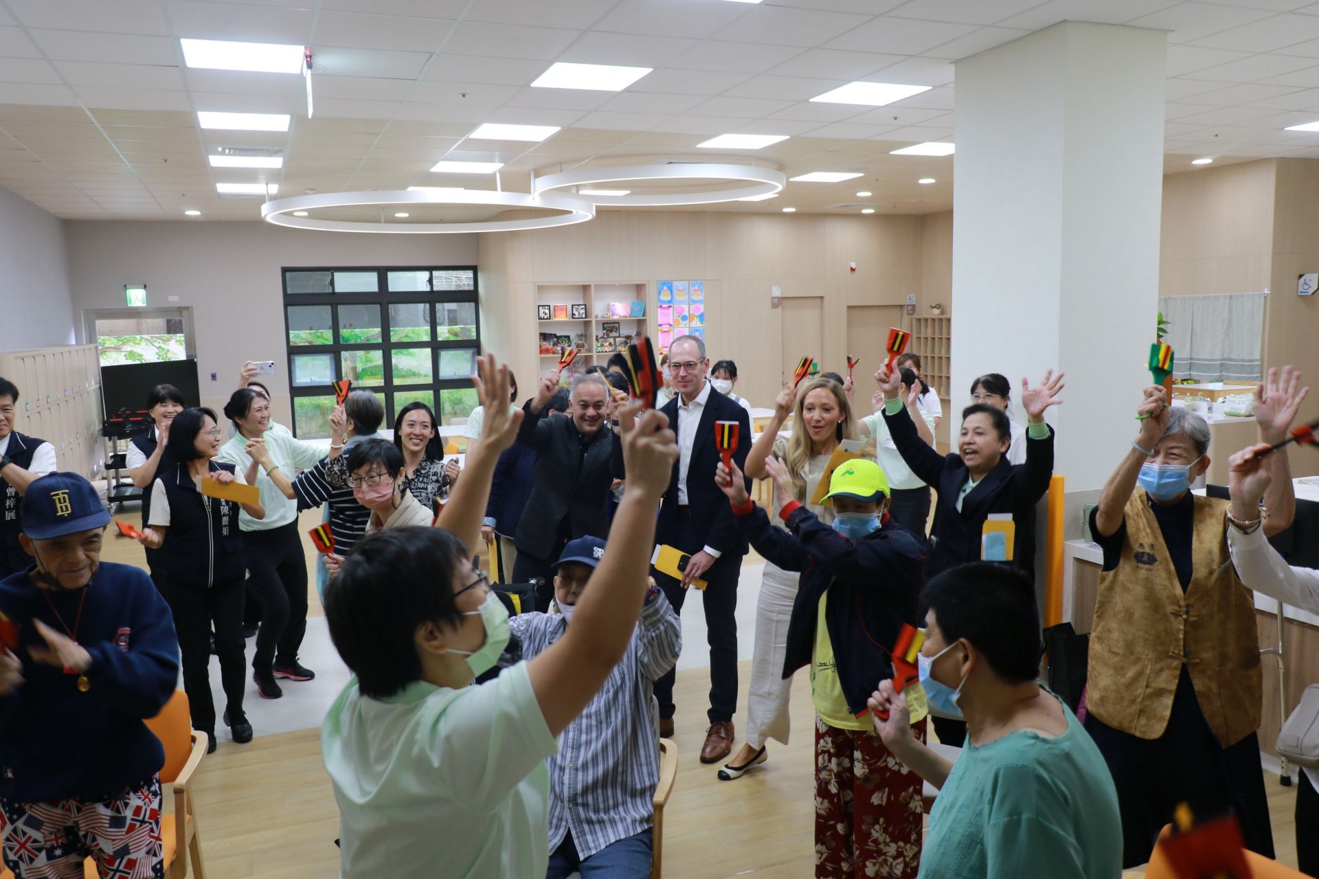 美國衛生福利部代表團在音樂治療區與長輩一起敲響板同樂，讚賞機構以人為本的服務理念，值得學習並帶回美國推廣。