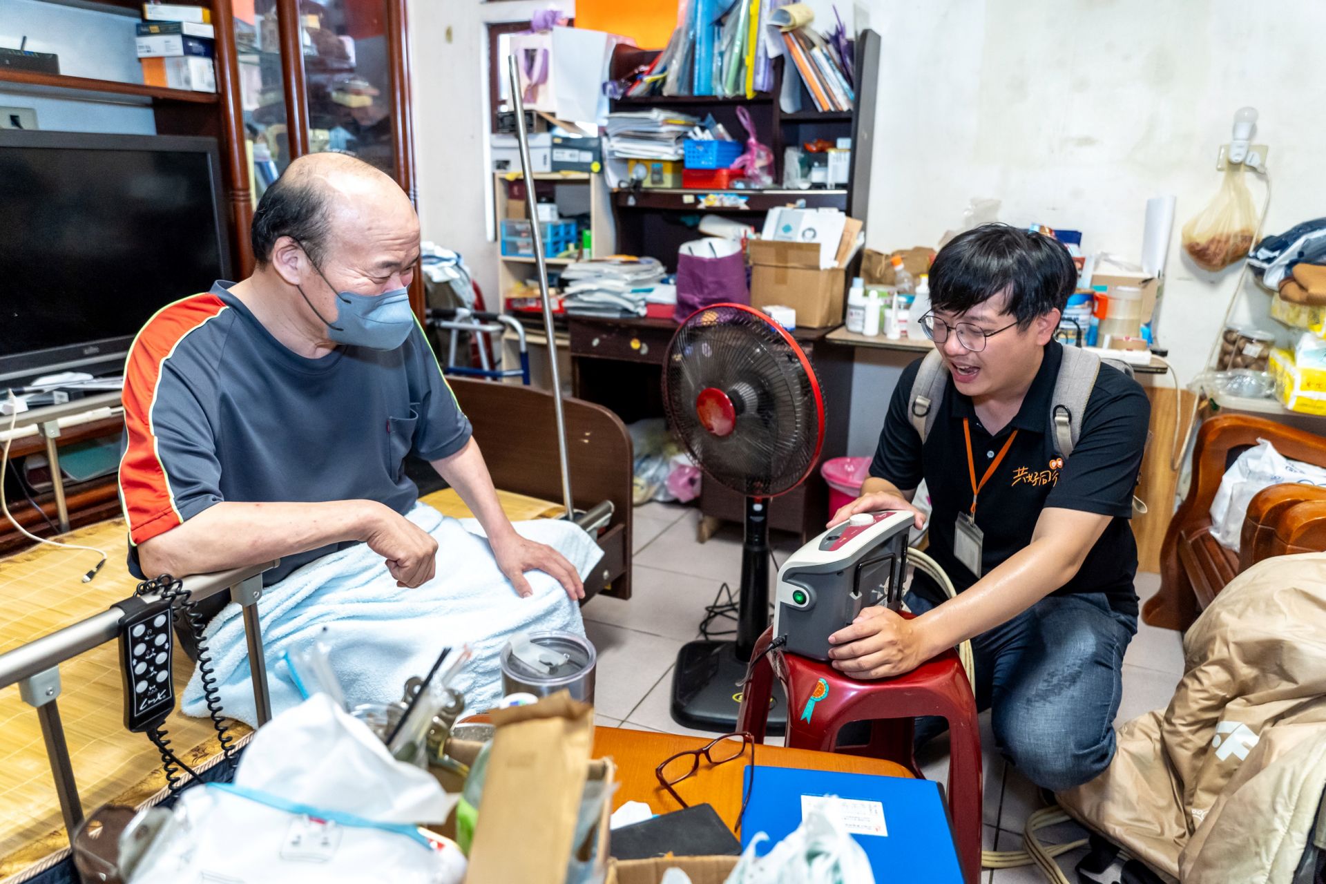 職能治療師李毅宏(右)主動出擊,風雨無阻的到宅評估服務對象的輔具使用情形,並進行必要的調整。