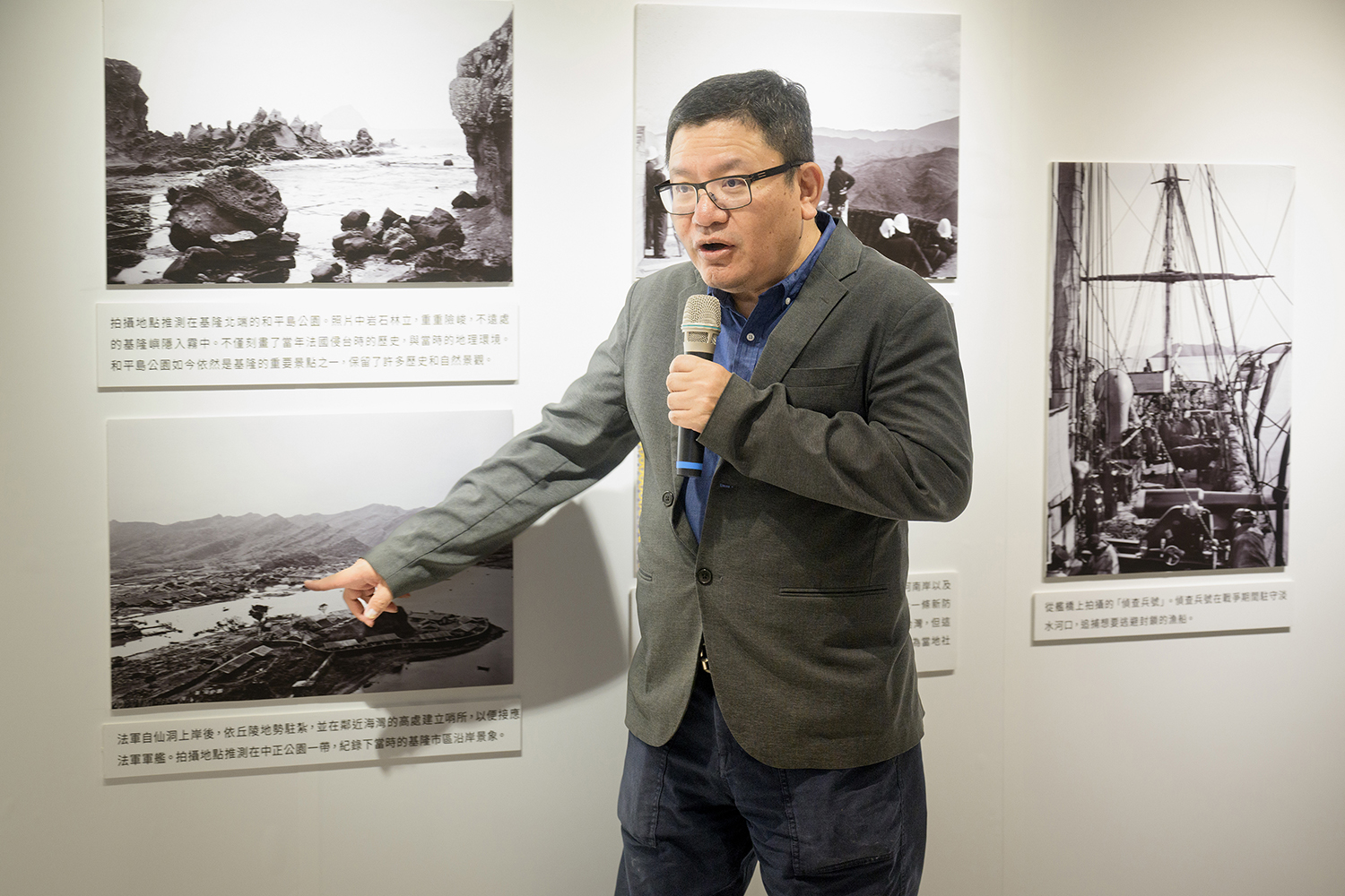 基隆市方定安秘書長藉由展覽中的昔日影像,向與會來賓指出慶安宮以前的位址所在。