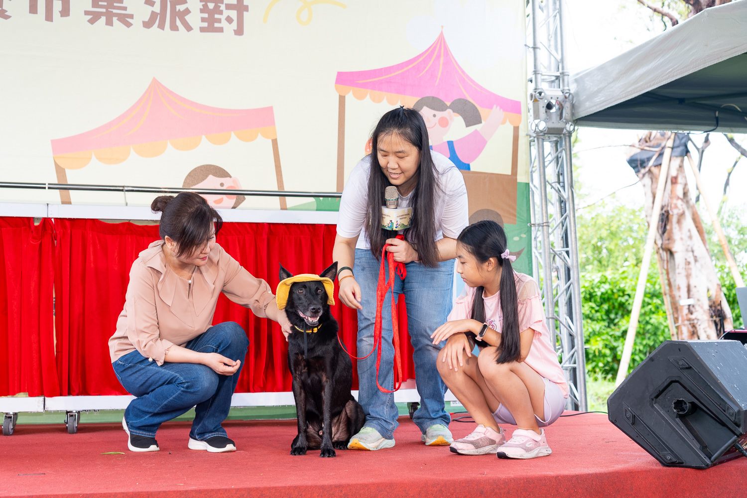 訓犬師帶領副局長與小朋友為待認養犬隻裝扮及學習正確配戴胸背帶及牽繩並一同走秀。