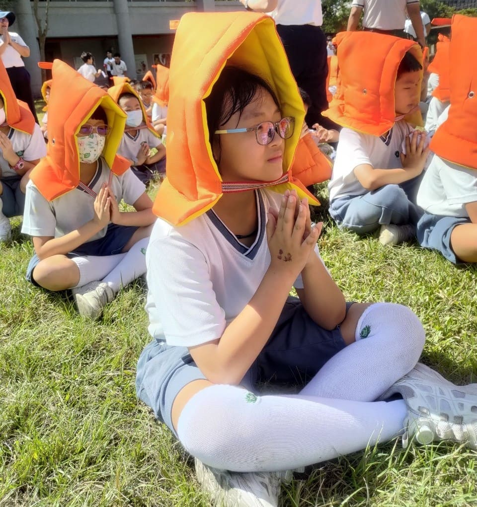 學生抵達集合地點後安靜等待並唱誦祈禱,祈求天下無災。