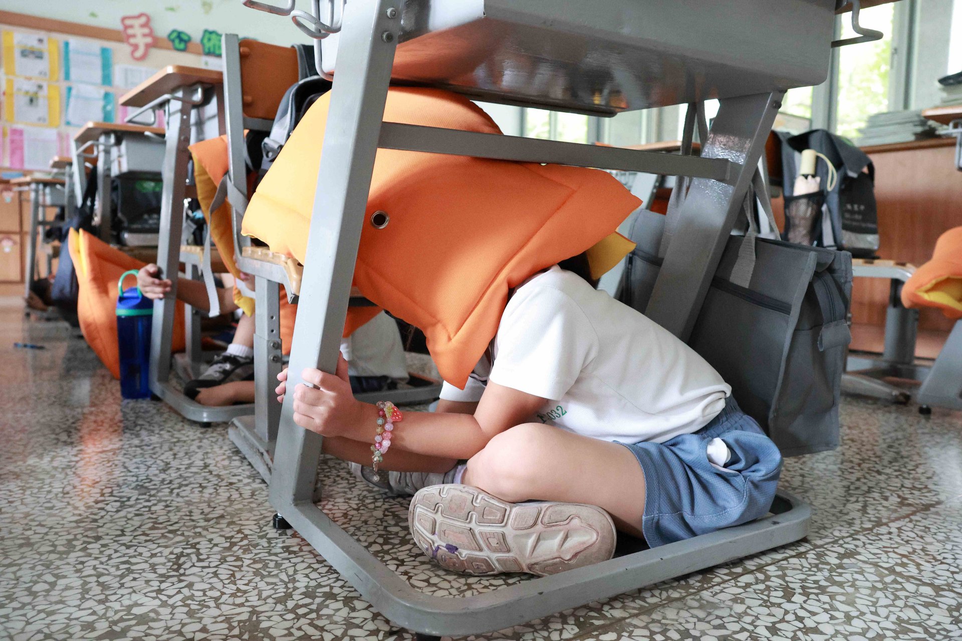 臺南慈小的孩子們在老師引導下,依序進行「趴下、掩護、穩住」的保命三要領。