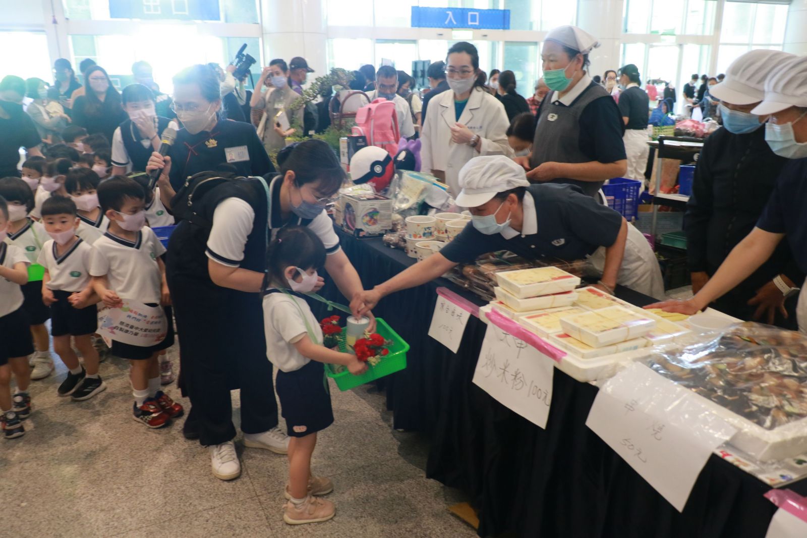 台中大愛幼兒園小朋友將親手製作的康乃馨繞場義賣,可愛模樣吸引眾人搶購。