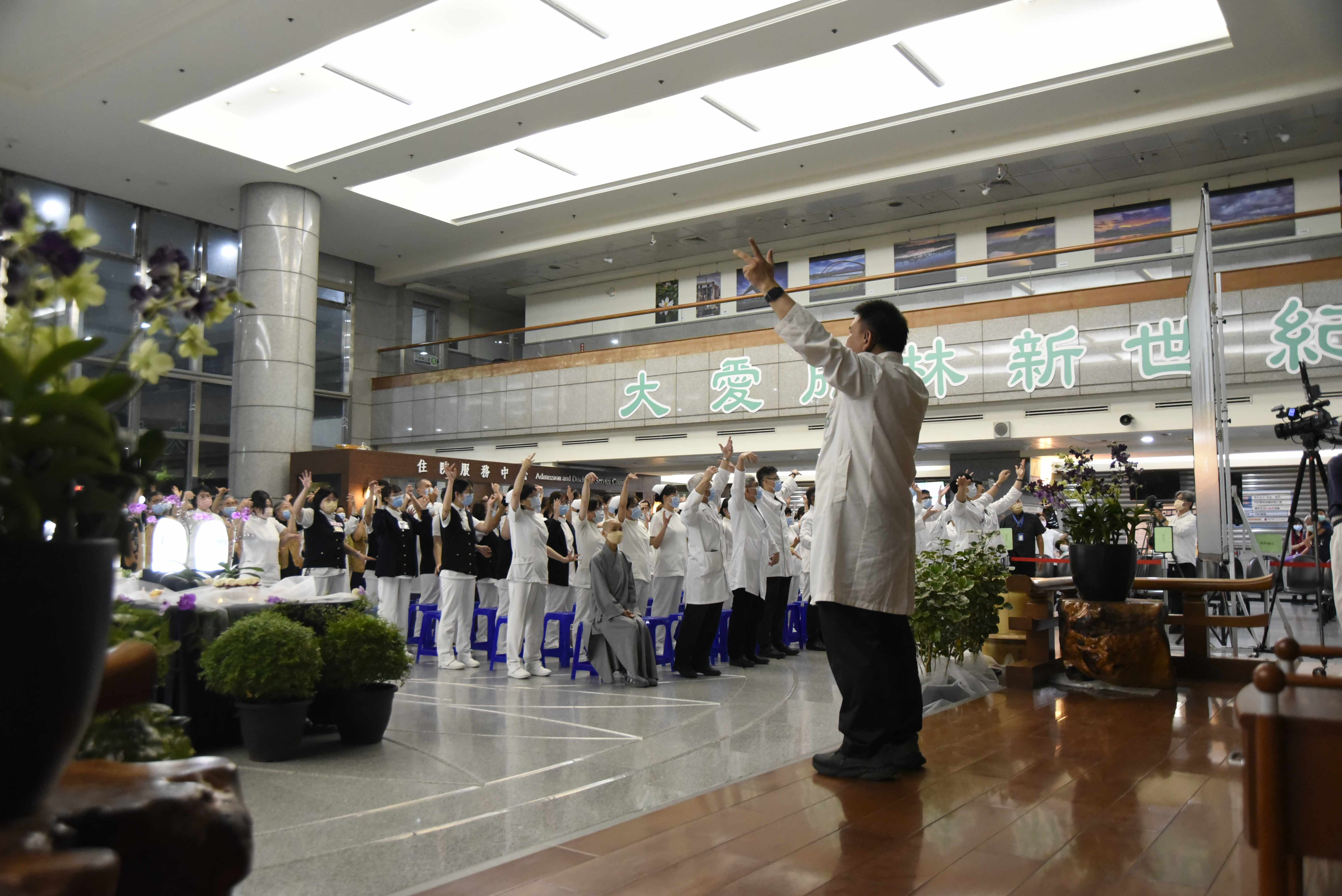 為了讓同仁在忙碌工作之餘,也能放鬆身心、提升健康,中醫部主任葉明憲帶領住院醫師現場教導「勇健梵唄」無量義經法髓頌健身操