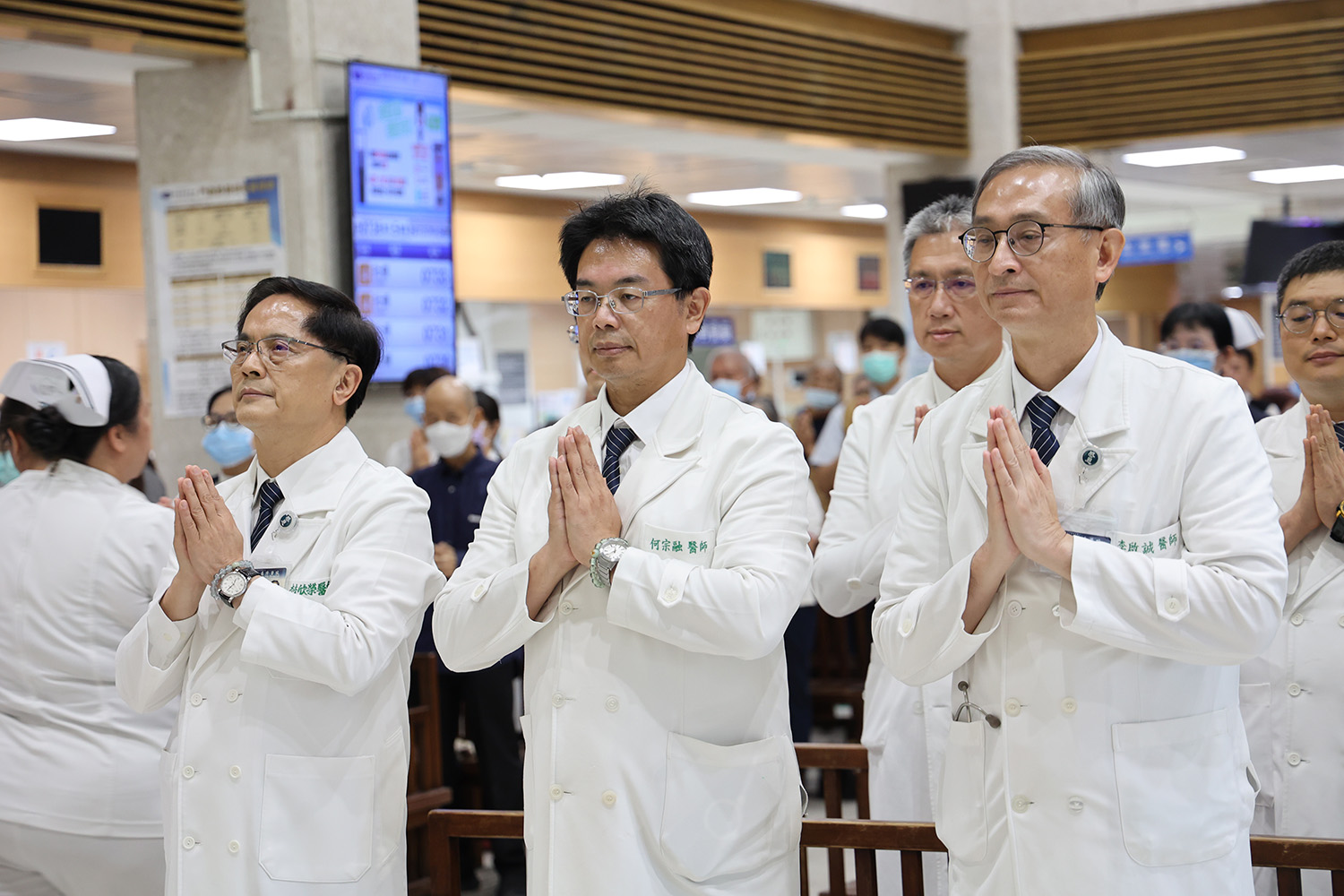 門診大廳內,眾人齊聲稱頌諸佛菩薩,虔誠合掌,共同唱誦「無量義經德性品梵唄」。(圖/宋雨安)
