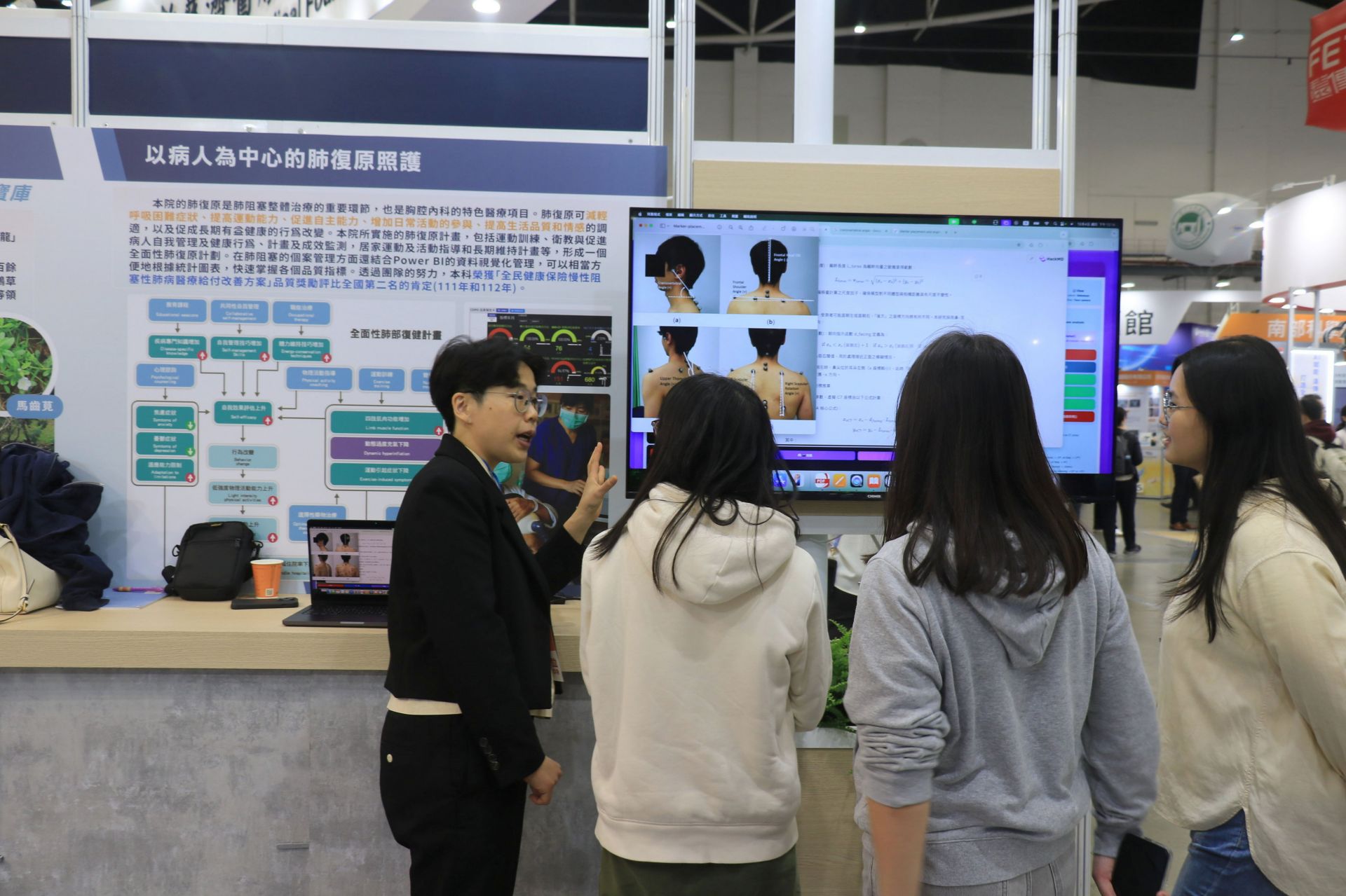 陳佳菁醫師(左)在展位向民眾解說「AI智慧姿勢評估系統」,透過電腦視覺技術,精準分析背部骨骼排列與歪斜程度。