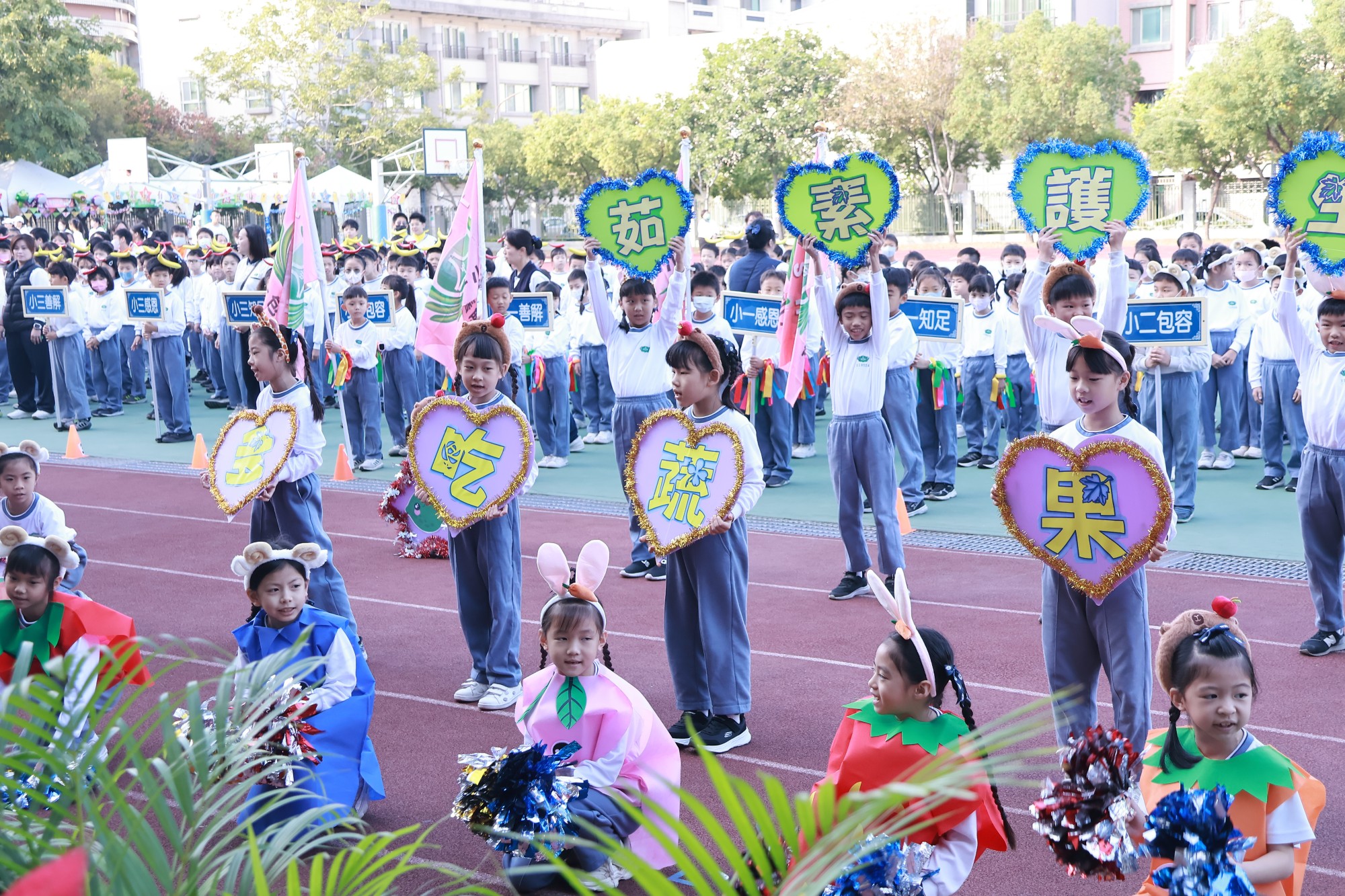 小學部學生推廣素食,身著蔬果裝,賣力隨著音樂舞動(左圖)。二年級頭戴動物髮箍,裝扮成吃素的小動物,傳達蔬食護生信念(右圖)。