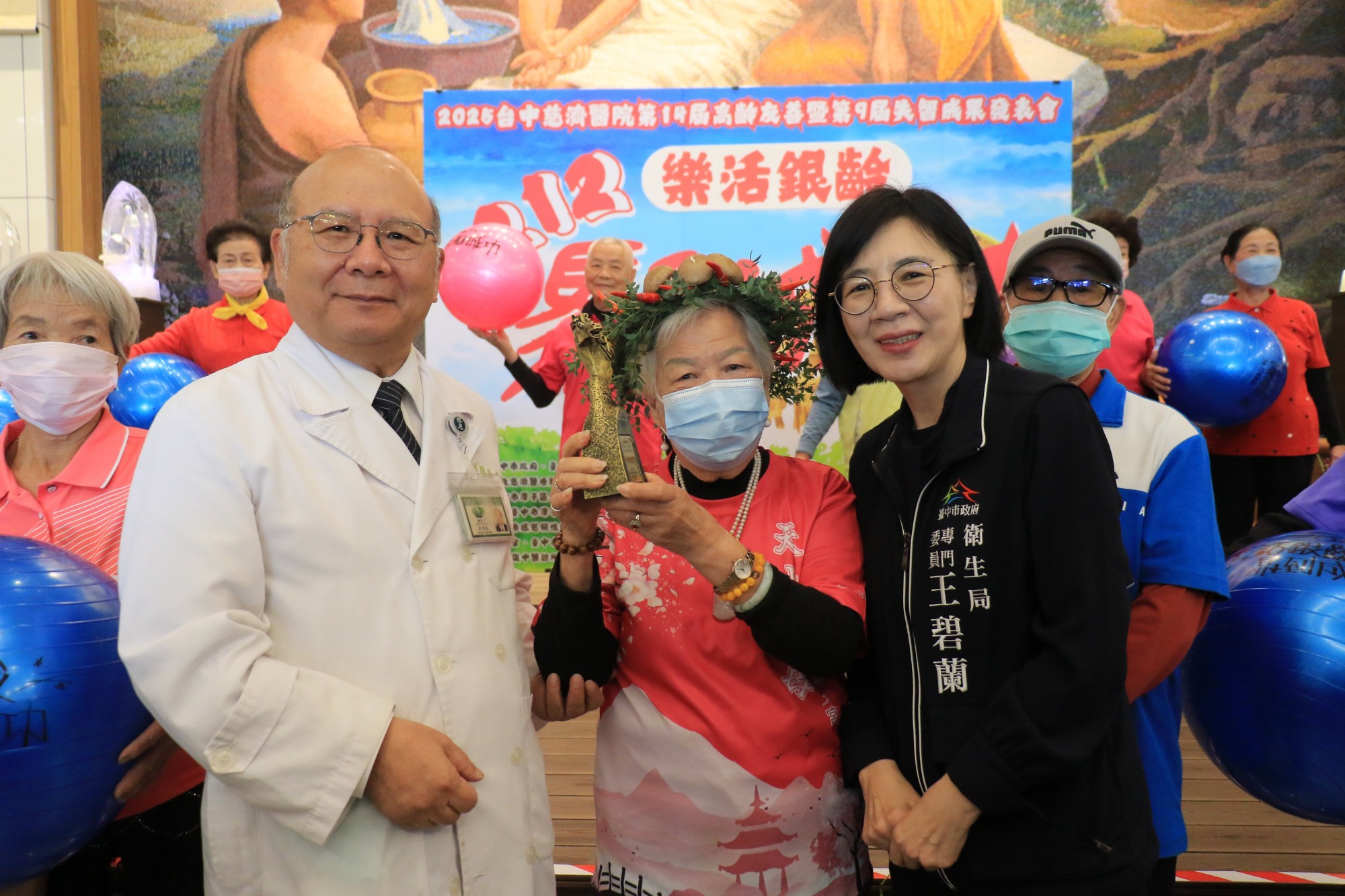 台中慈濟醫院副院長許權振(左)與臺中市衛生局專委王碧蘭(右)頒獎給肌力挑戰賽第一名的元奶奶(中)。
