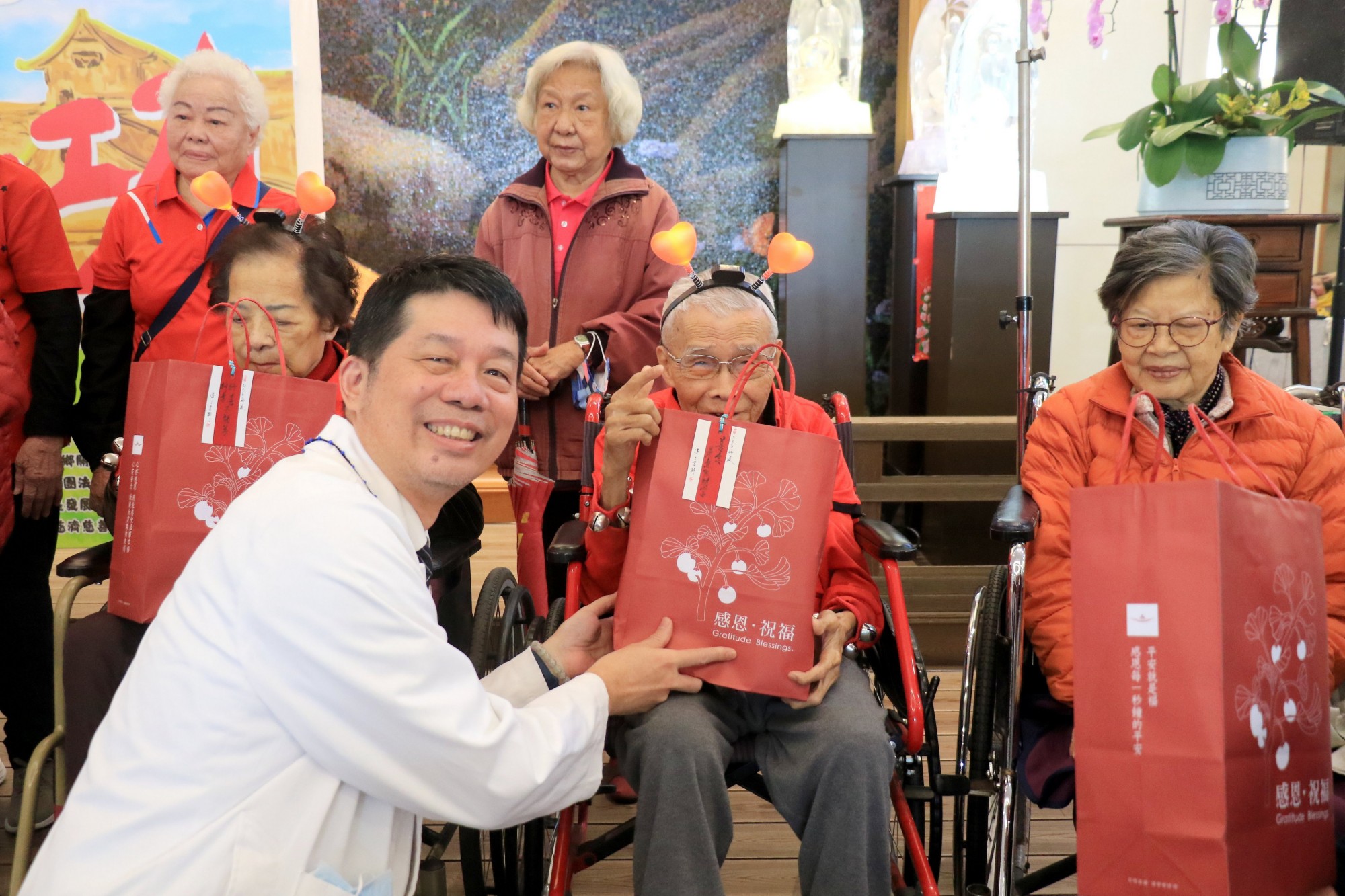 社區健康中心主任陳慶元(左)頒發結緣品給90歲以上的長輩,感恩他們長期的參與並祝福健康平安。