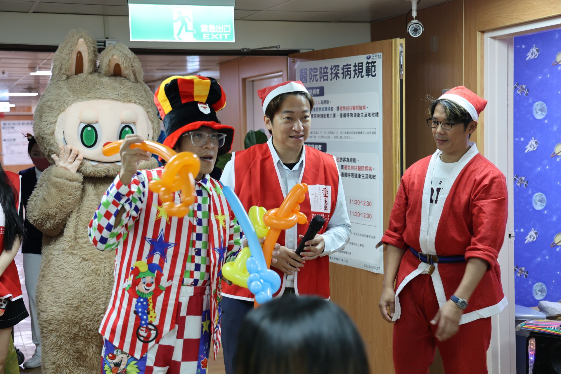 耶誕音樂一響起,雷恩叔叔(左一)大展魔術身手,氣球一下從「一變二」,逗得小朋友們驚呼連連。他還根據小朋友們的喜好將氣球折成寶劍、小狗與玩具槍等造型。