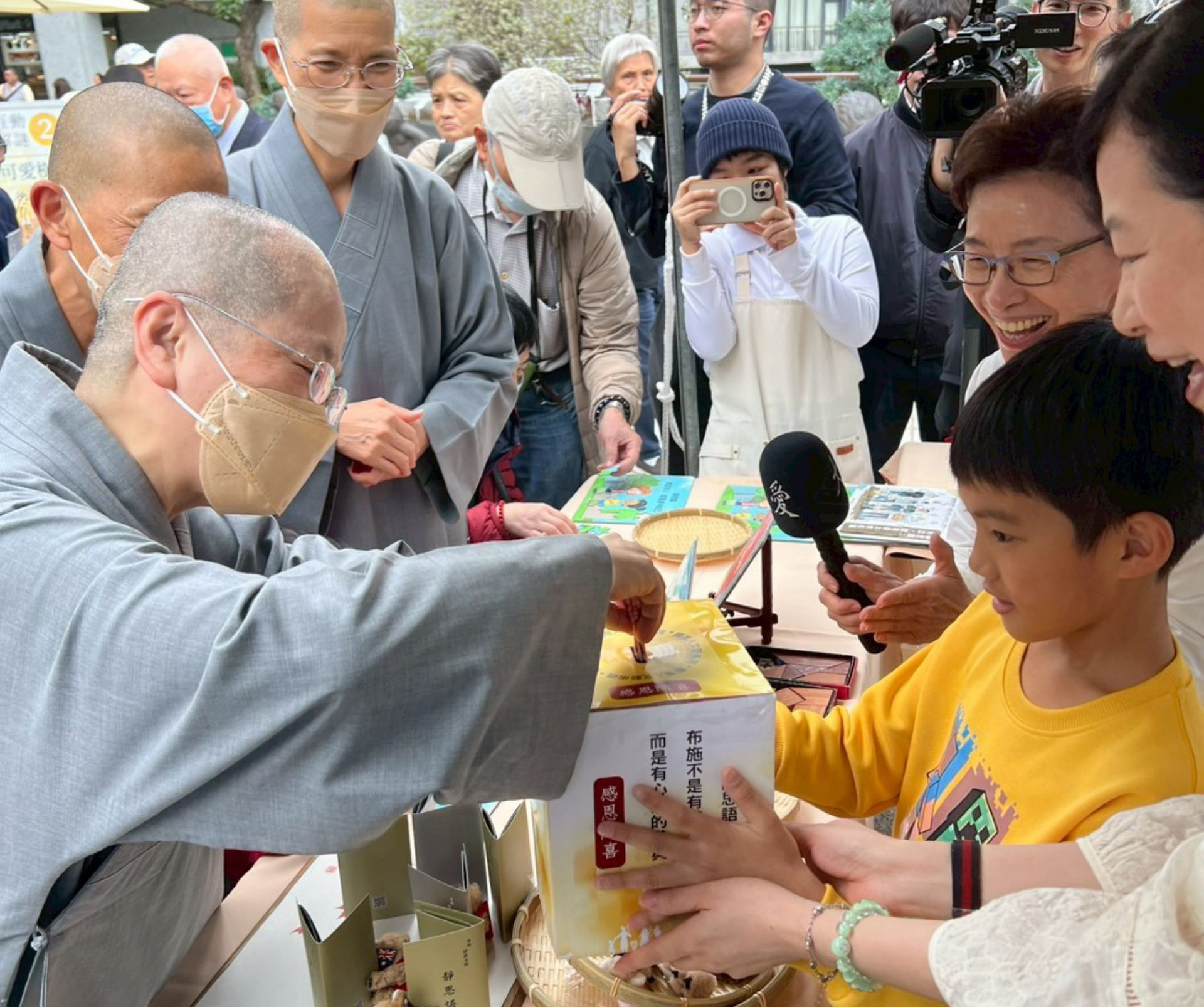 靜思精舍常住師父到各攤位感恩志工們的付出。在紀雅瑩師姊的鼓勵下,原本害羞、不敢與陌生人交談的吳O恩(黃上衣)勇敢挑戰「一日店長」。