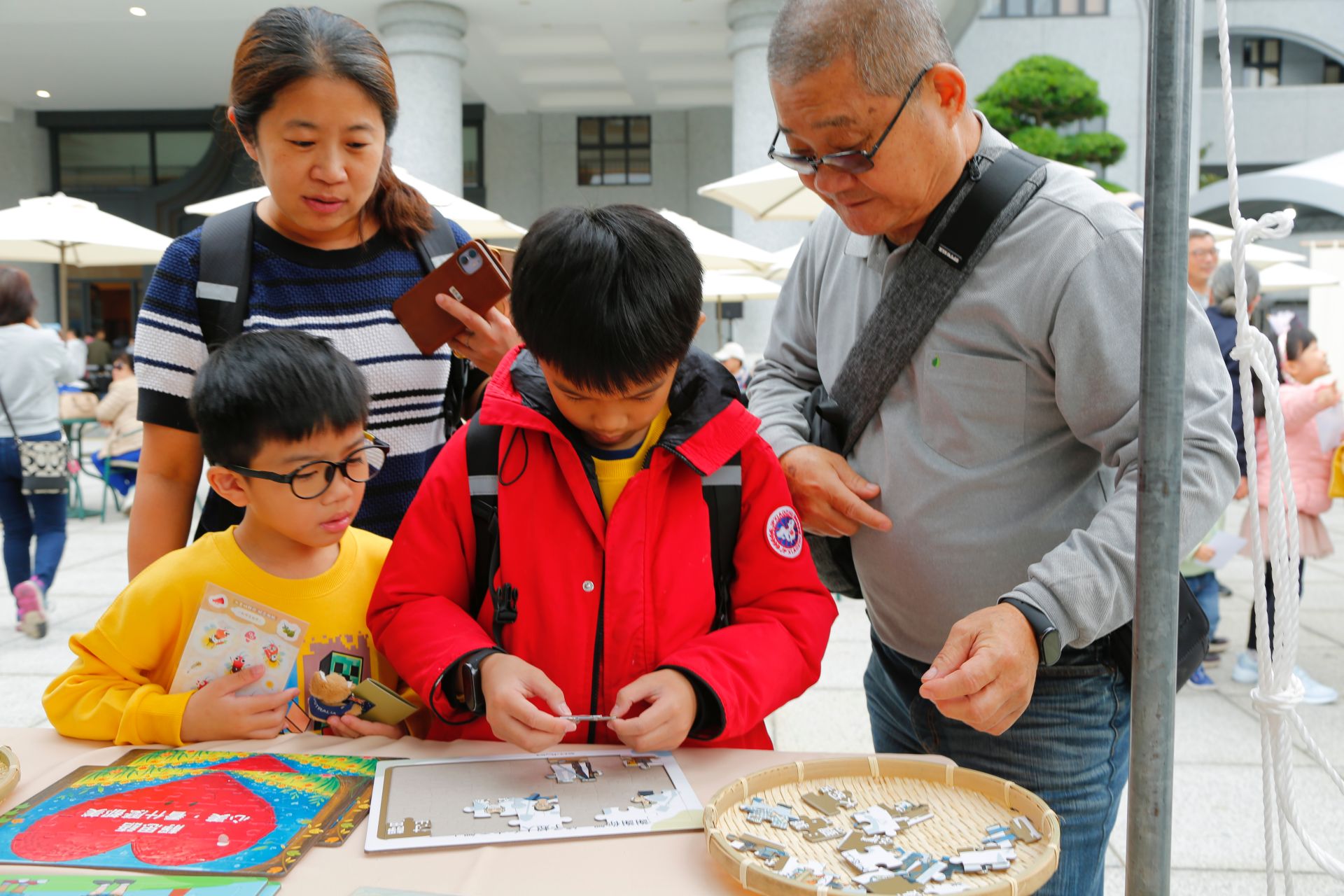 一幅「鏟子超人」拼圖吸引了吳O恩(前排中)的目光。他仔細觀察,將零散的拼圖,逐步拼湊成圖。