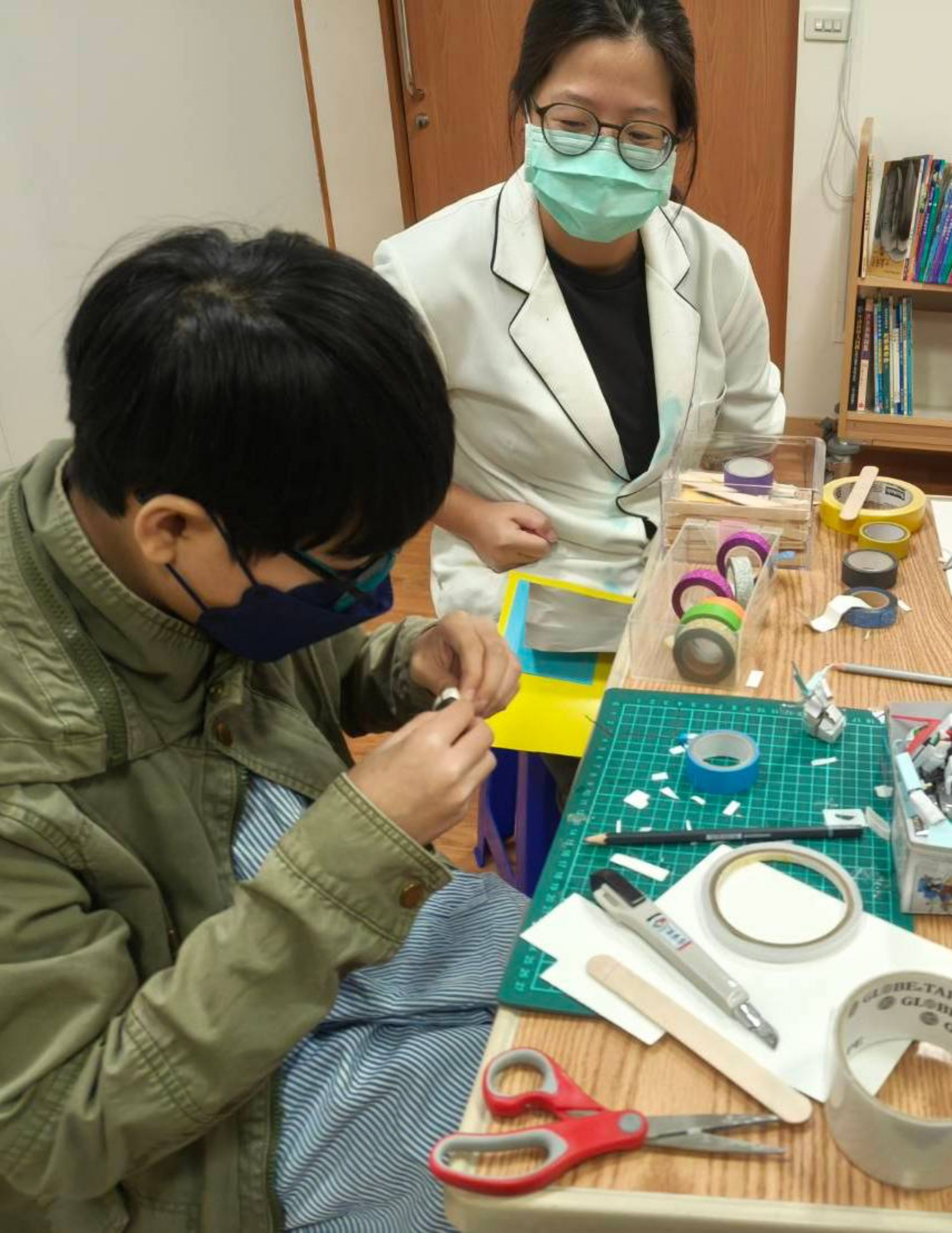 藝術治療師與音樂治療師到病房,藉由音樂與手作遊戲,減輕樂樂住院不安的情緒。
