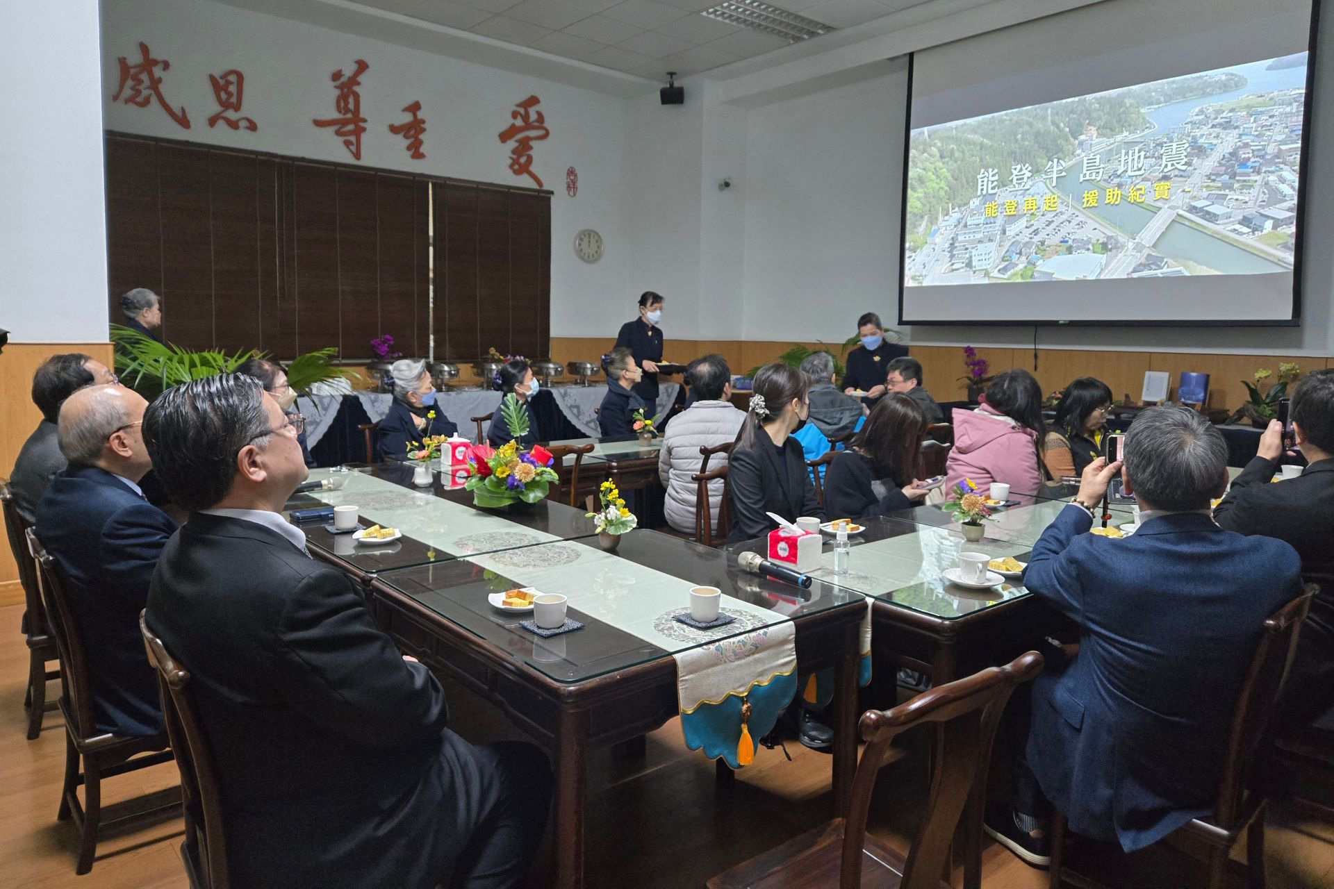 現場播放回顧志工用行動賑災與災民互動的寫實影片。