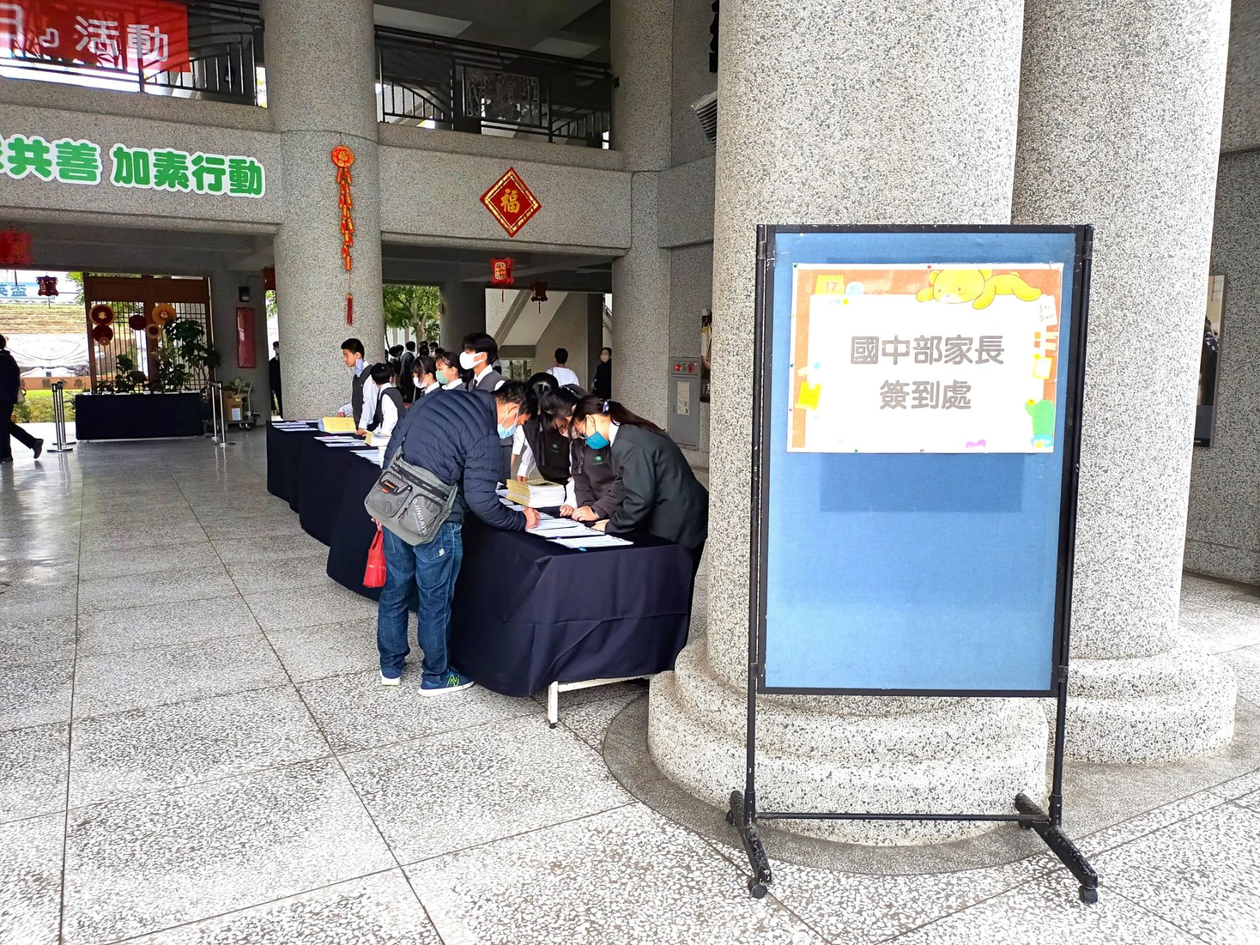 學生志工引導家長簽到。