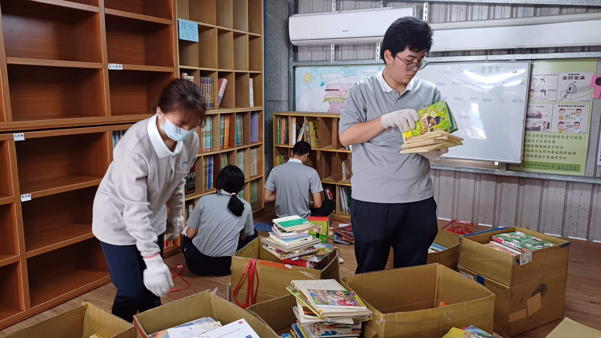 同學們仔細從裝箱中取出書籍系統分類