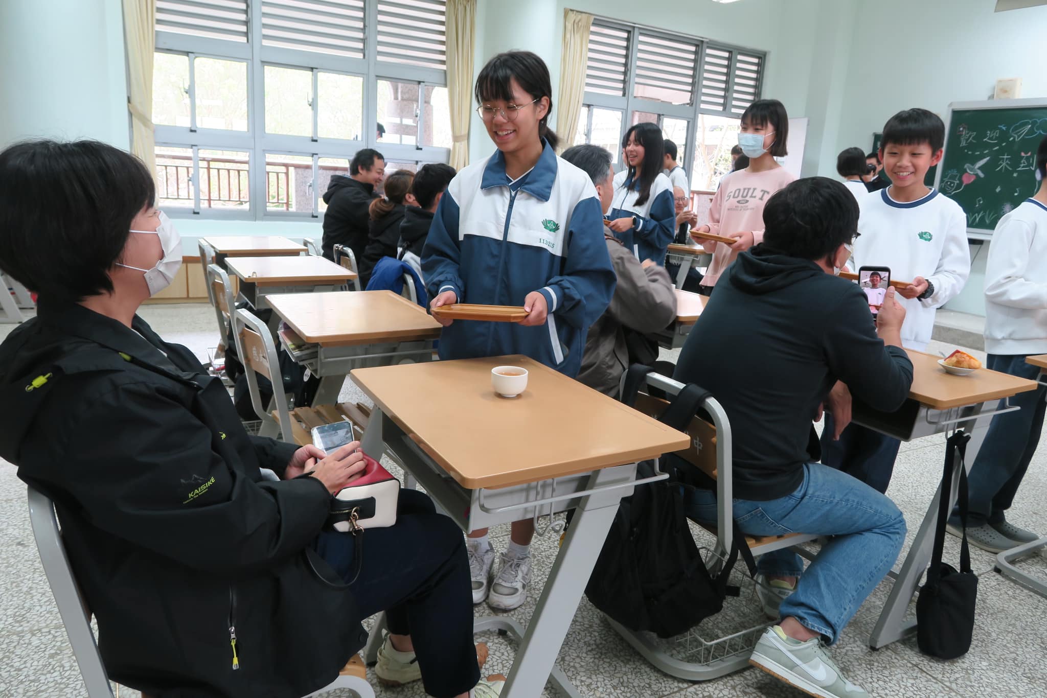 學生為家長奉上熱茶,表達感恩之情,溫馨氛圍讓家長們深受感動。