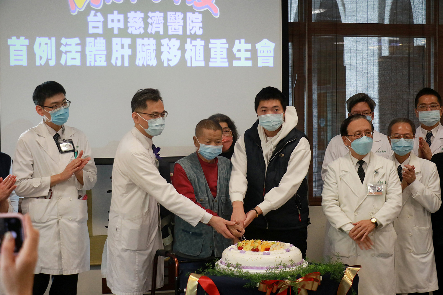 簡守信院長(右二)與鄭紹彬主任(左二)率領醫療團隊,為翁姓父子送上祝福蛋糕,共慶重生。